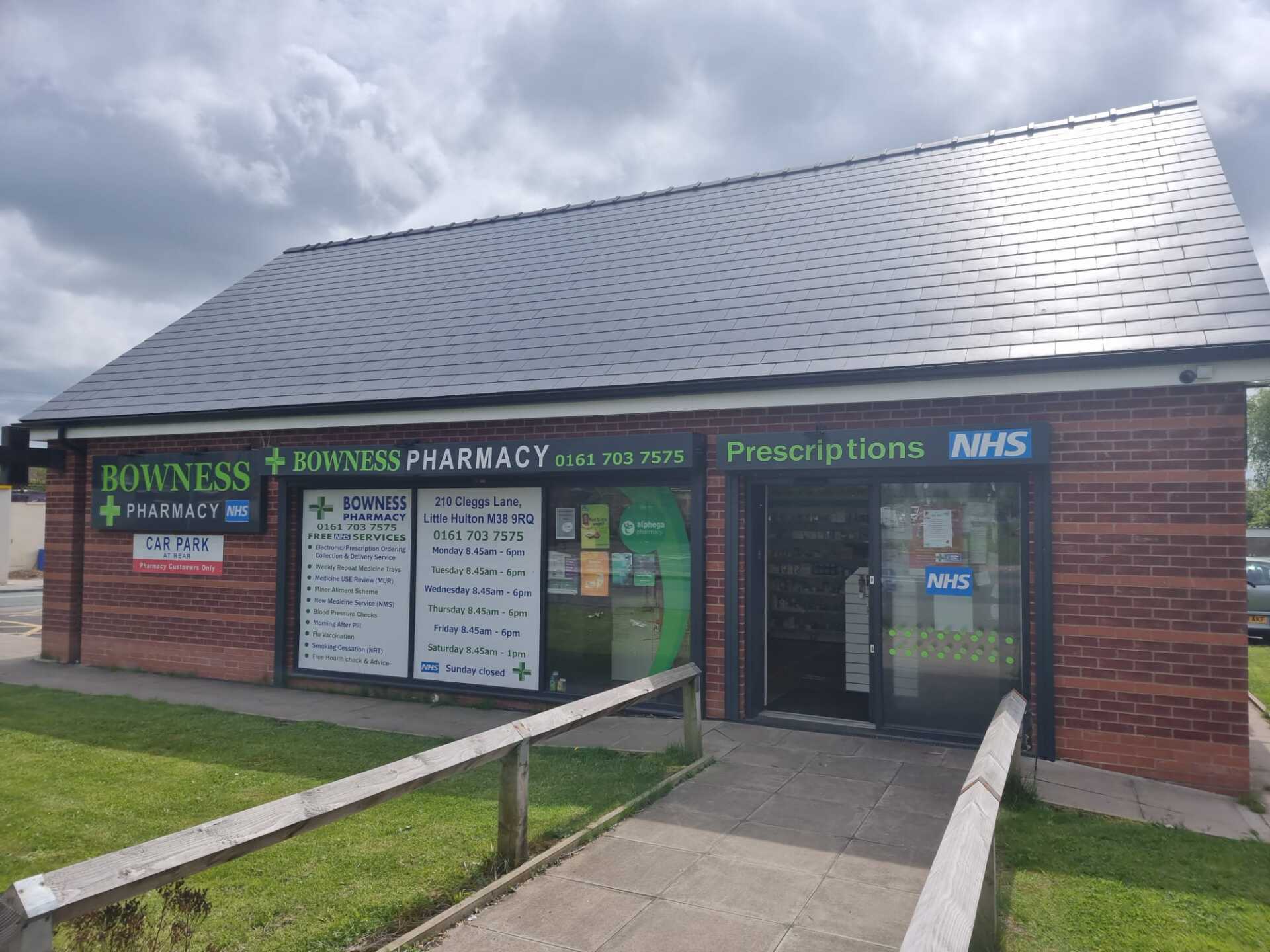 A brick building with a slate roof and a ramp leading to it.