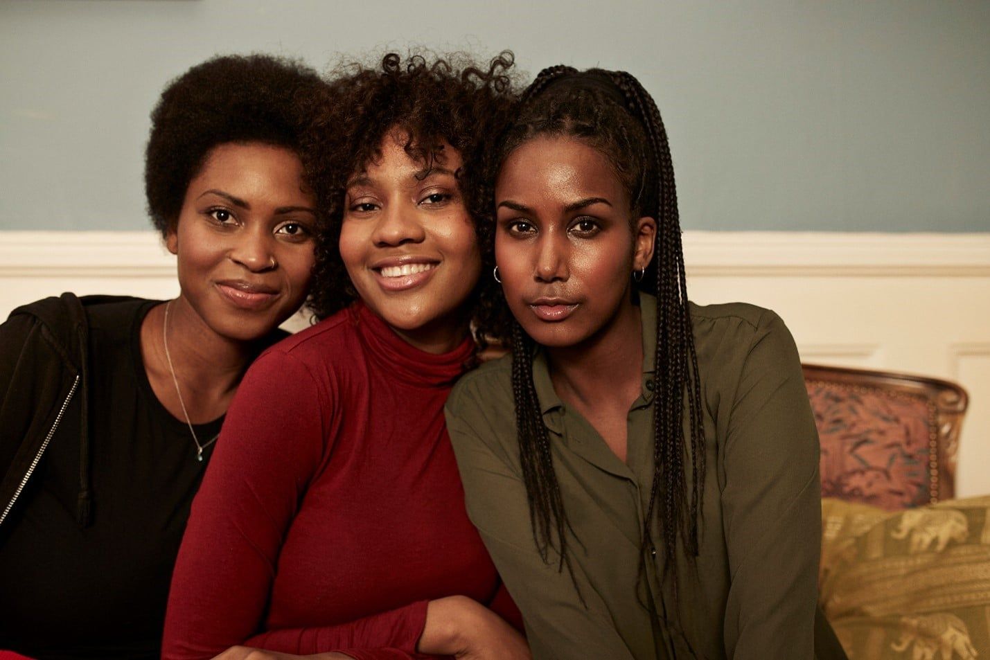 Three Women Are Posing for a Picture Together While Sitting on a Couch — Care FNQ Pty Ltd in Cairns City, QLD