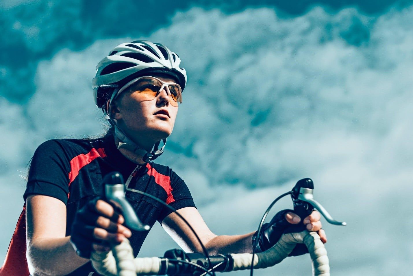 Woman Wearing a Helmet and Sunglasses is Riding a Bike  — Care FNQ Pty Ltd in Cairns City, QLD