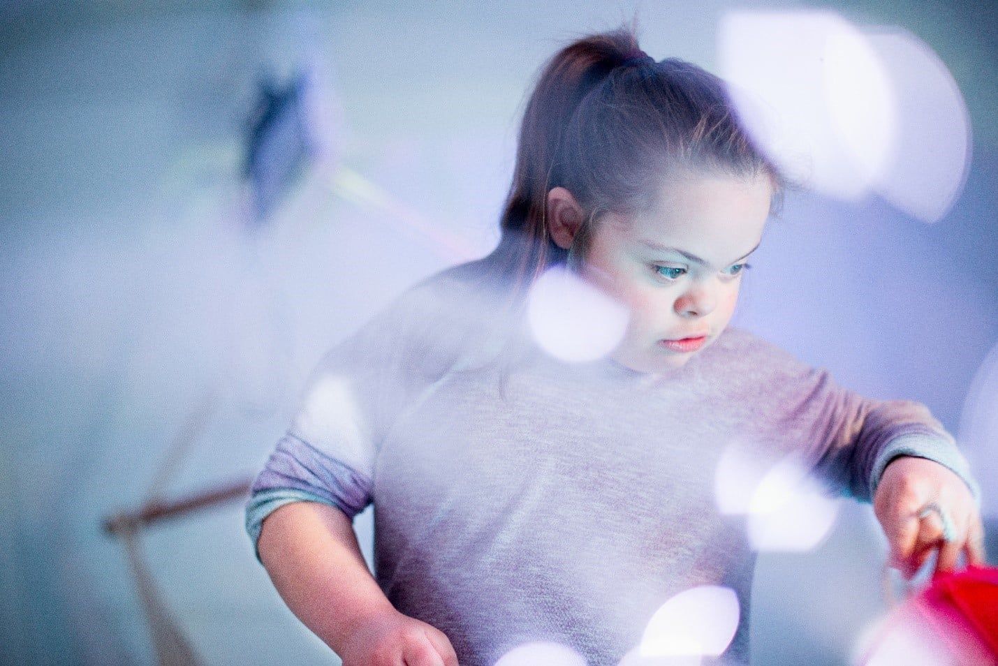 Girl with Down Syndrome Painting, With Soft Lighting and Bokeh — Care FNQ Pty Ltd in Cairns City, QLD