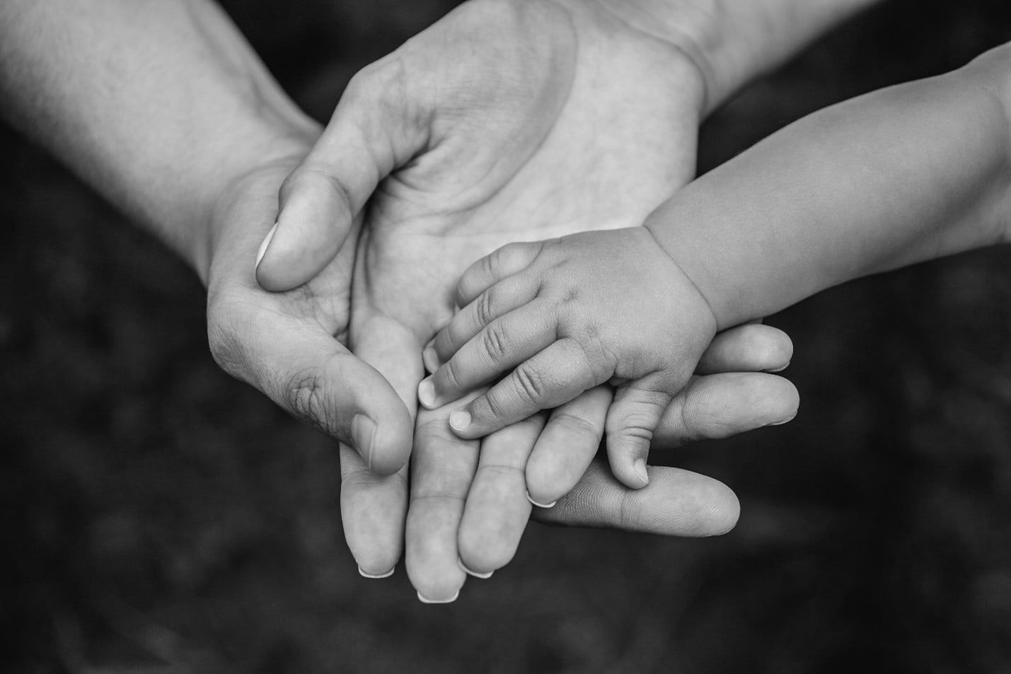 Black and White Photo of a Family Holding Hands — Care FNQ Pty Ltd in Cairns City, QLD