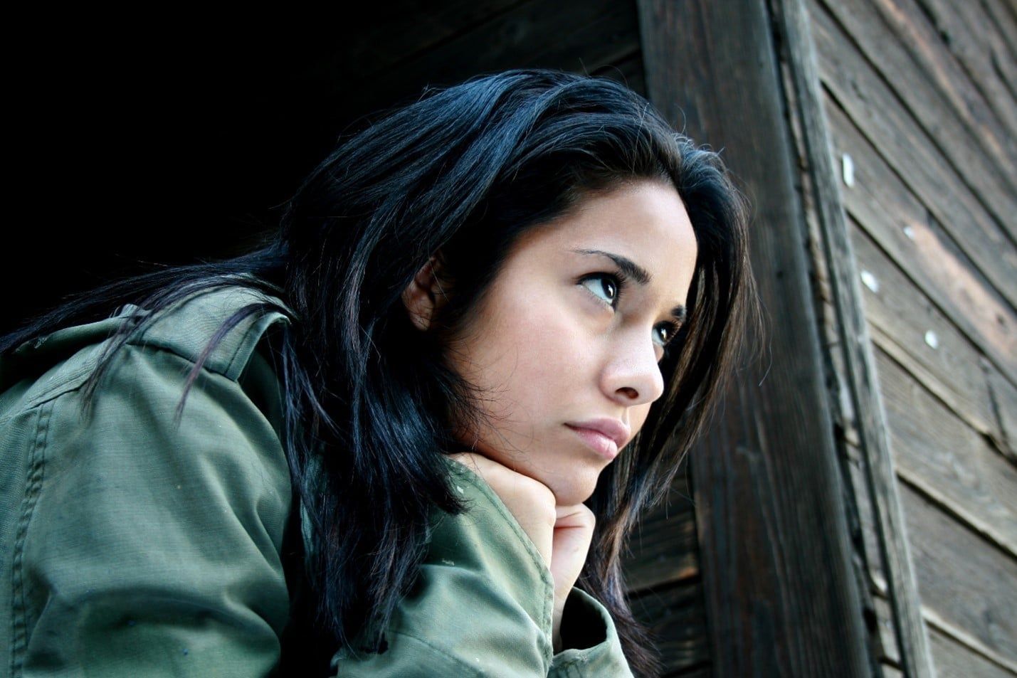 Woman in a Green Jacket is Looking Out of a Window — Care FNQ Pty Ltd in Cairns City, QLD