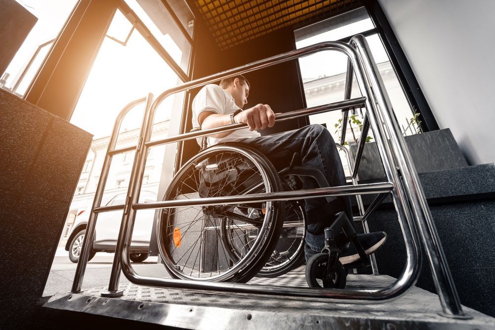 A Man in a Wheelchair is Sitting on a Ramp — Care FNQ Pty Ltd in Atherton, QLD