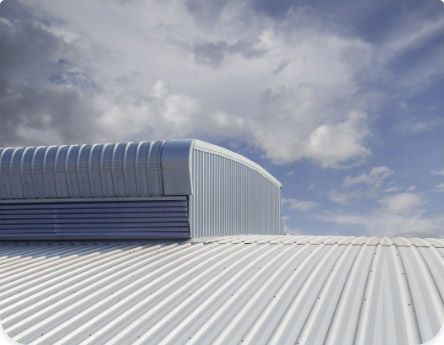 a white metal commercial roof with a blue sky in the background