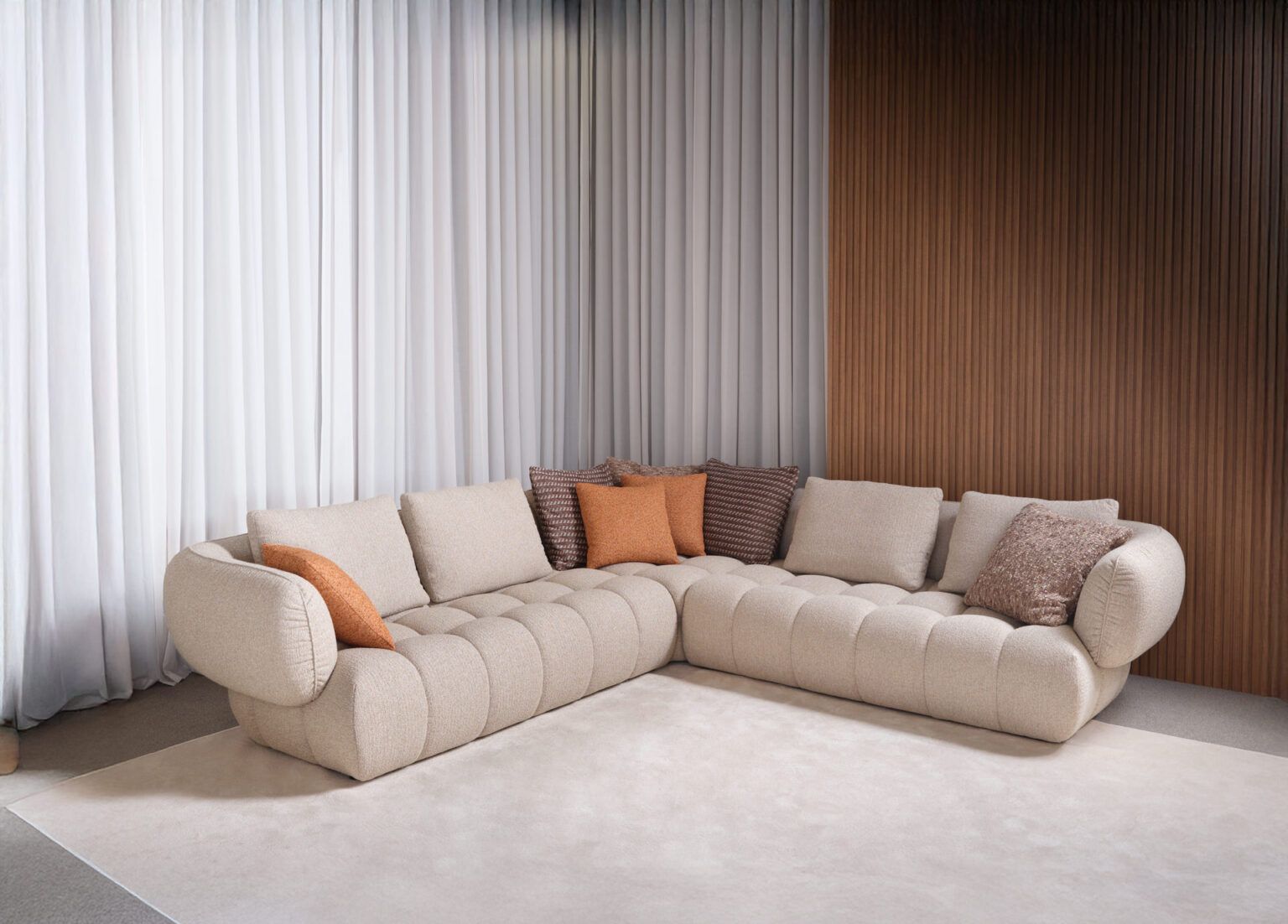 Un grande divano componibile è posizionato in un soggiorno, accanto a una finestra.