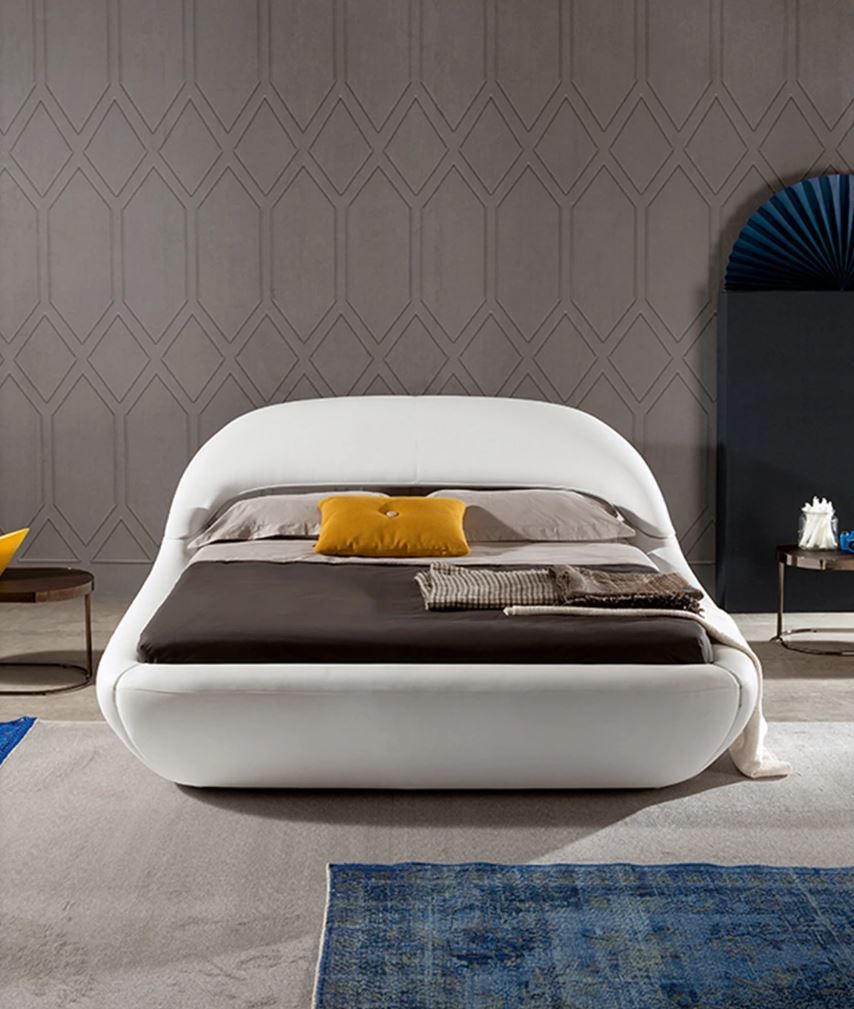 Un letto bianco con cuscini gialli in una stanza