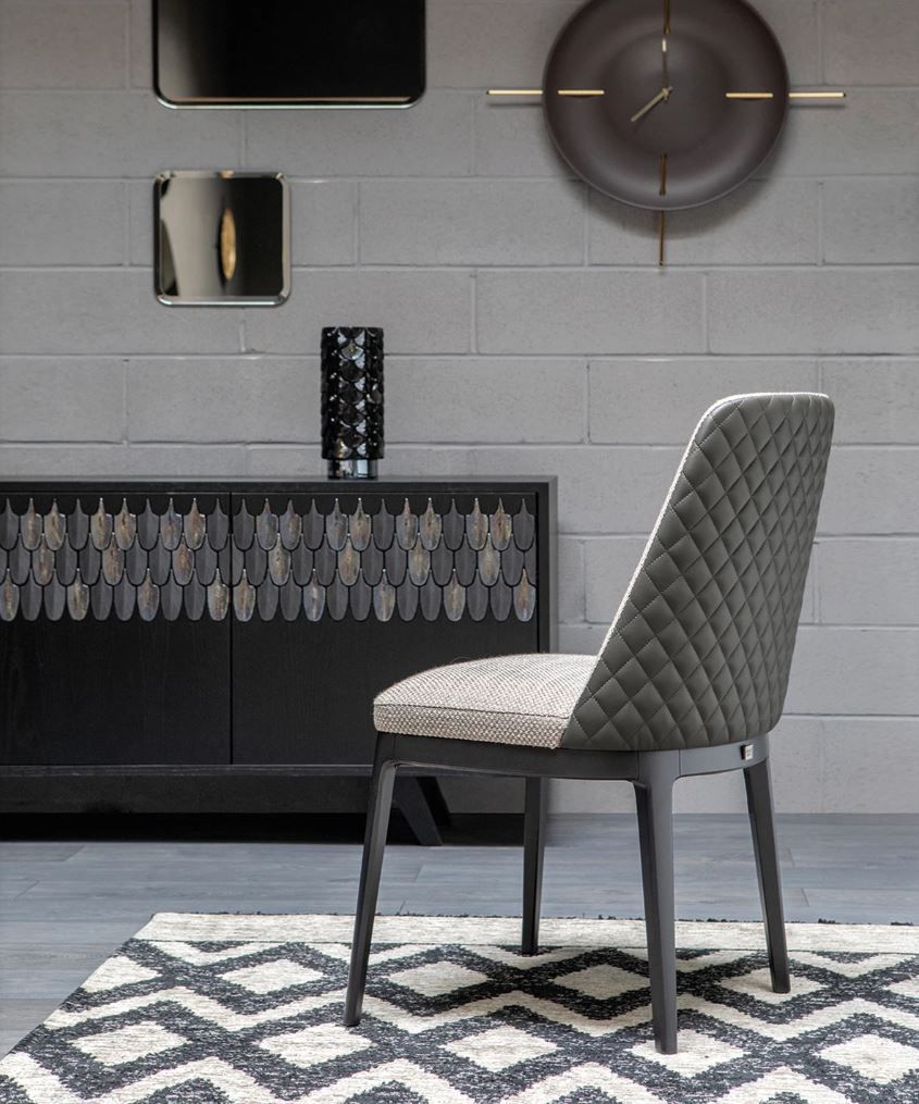 Una sedia in una stanza con un orologio sul muro sopra di essa