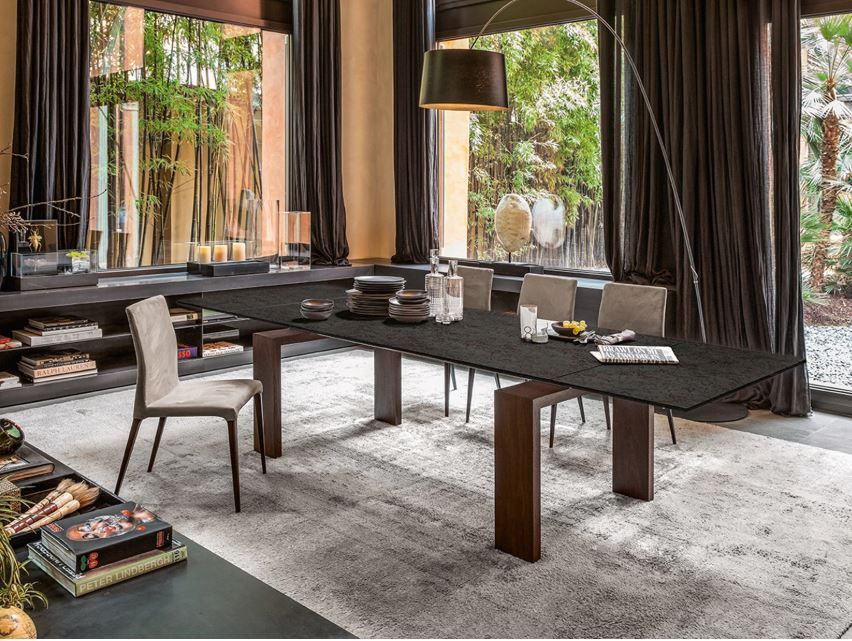 Un soggiorno con tavolo da pranzo, sedie e una grande finestra.