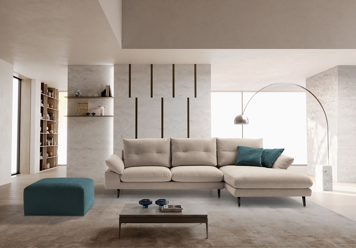 Un soggiorno con divano, tavolino, pouf e lampada.