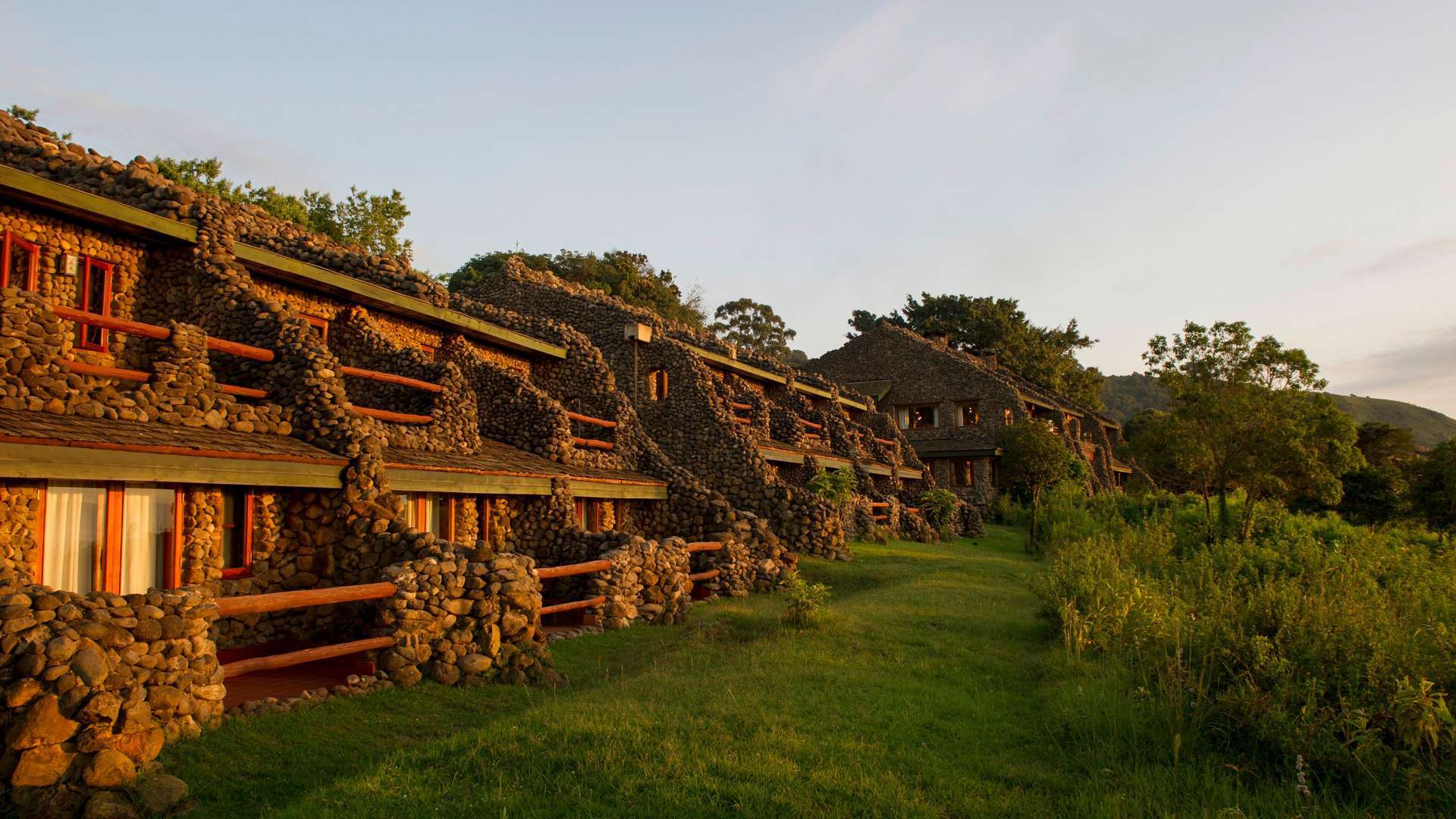 A row of stone buildings sitting on top of a lush green field.