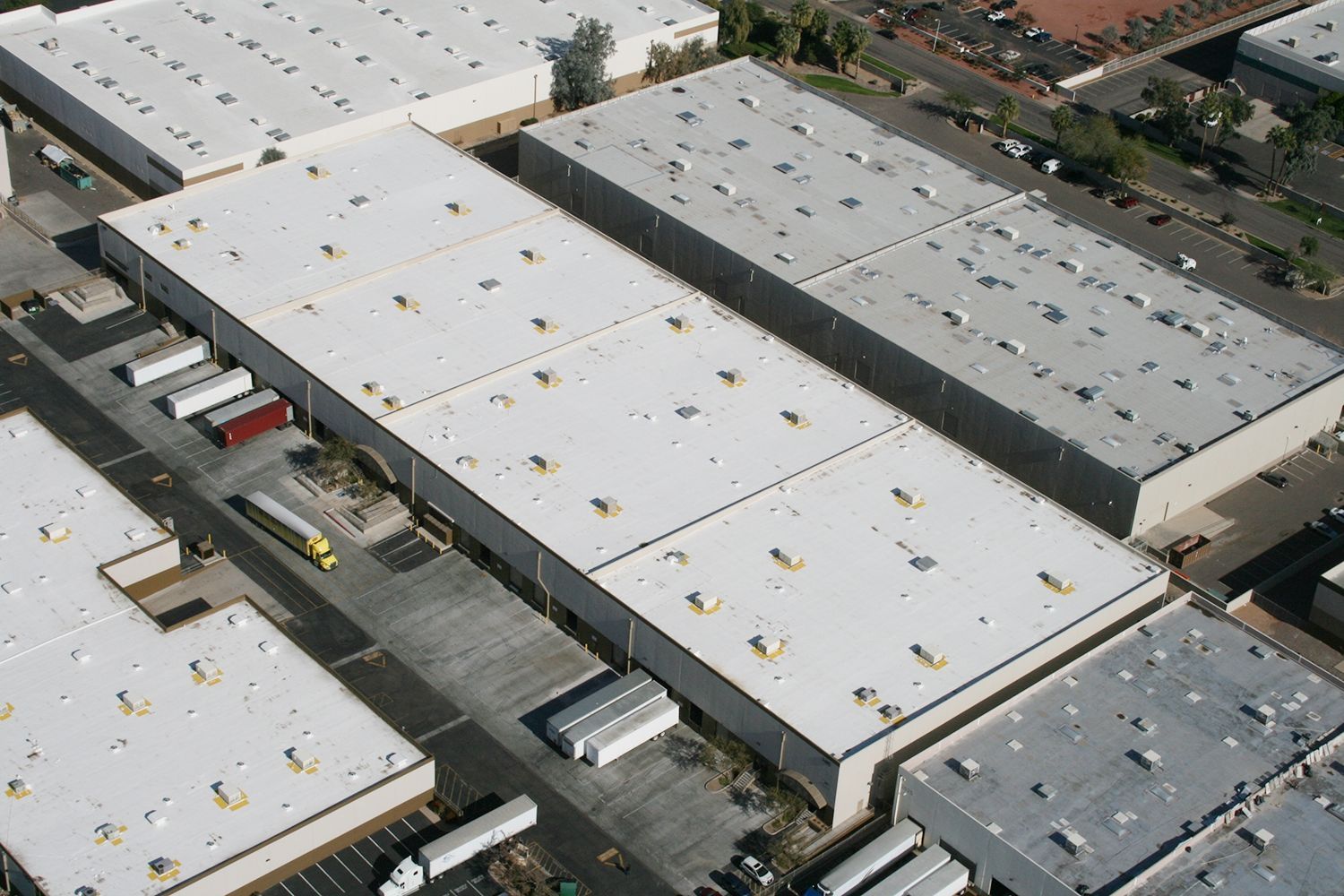 An aerial view of a warehouse with a lot of trucks parked in front of it