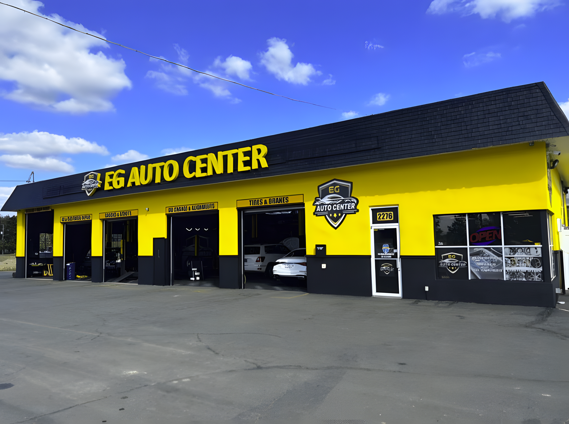 Goodyear Tire & Auto Center exterior. Several cars at service bays. Yellow and green car parked in front. | EG Auto Center