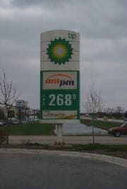 A bp gas station sign is sitting on the side of the road.