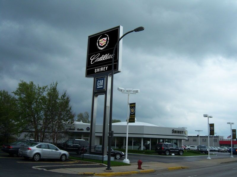 A cadillac dealership with cars parked in front of it