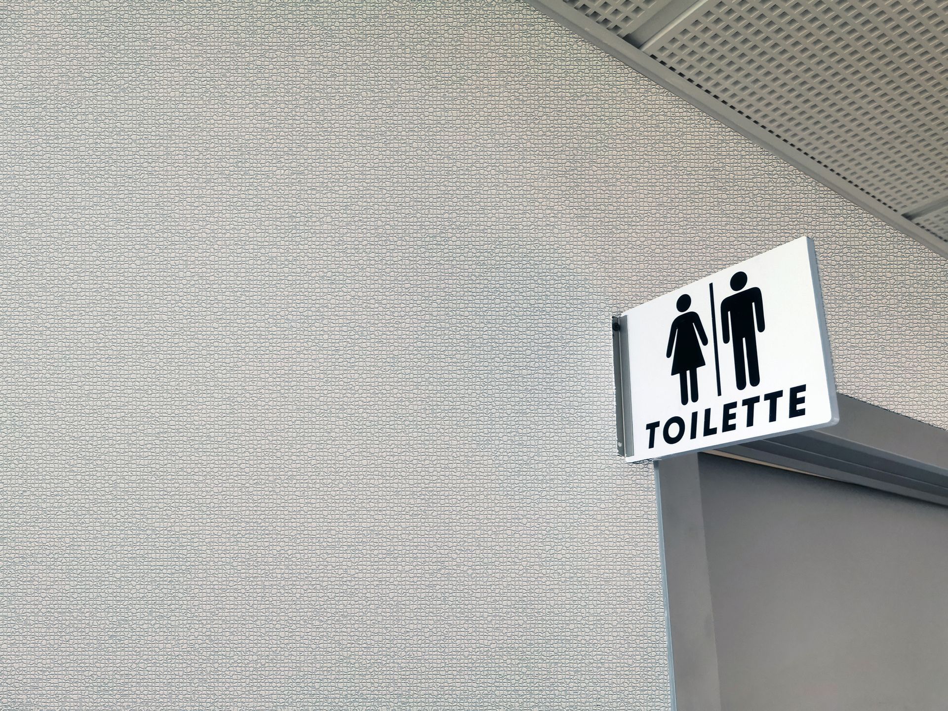 There is a sign on the side of a building that says toilette.