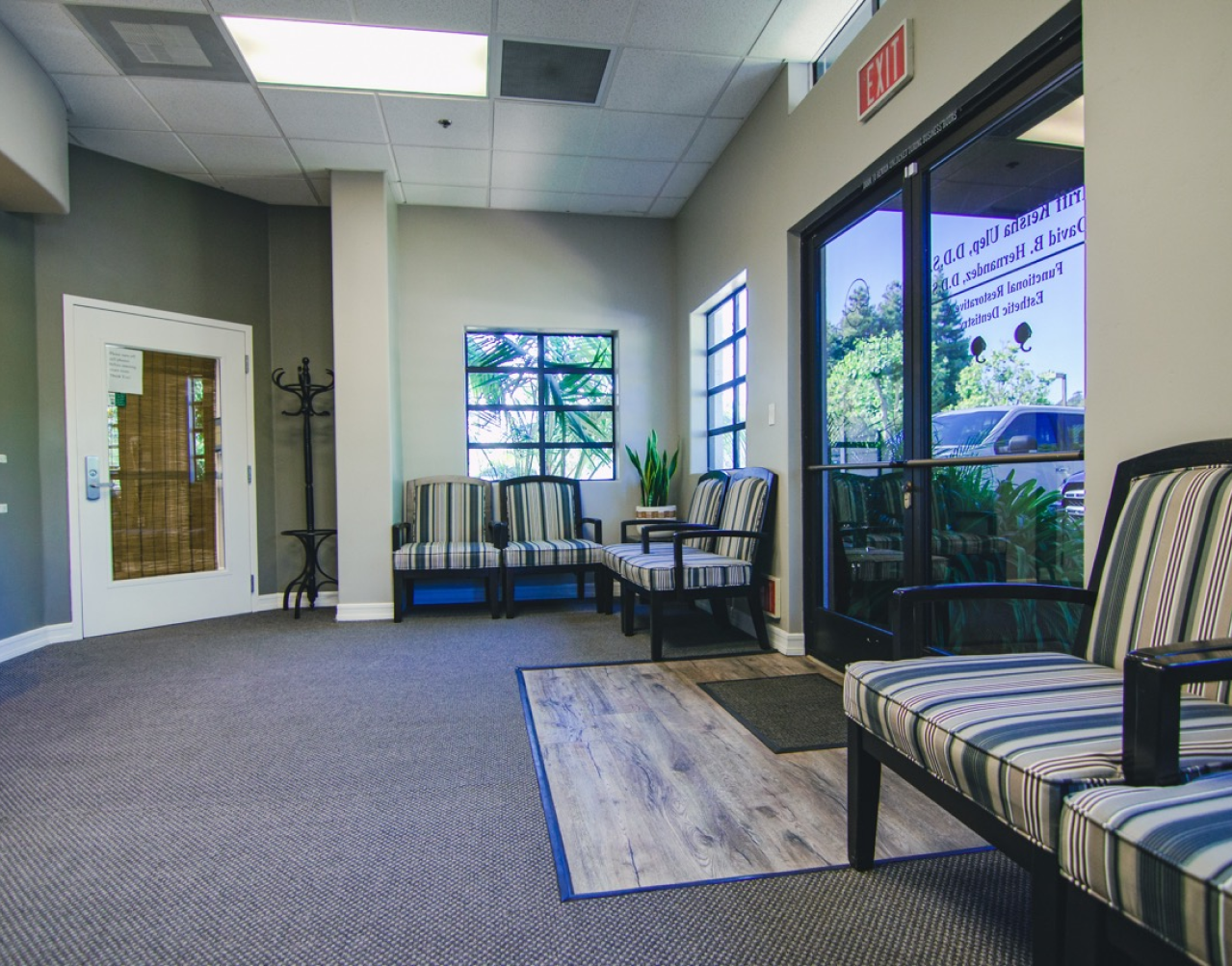 A waiting room with chairs and a sliding glass door.
