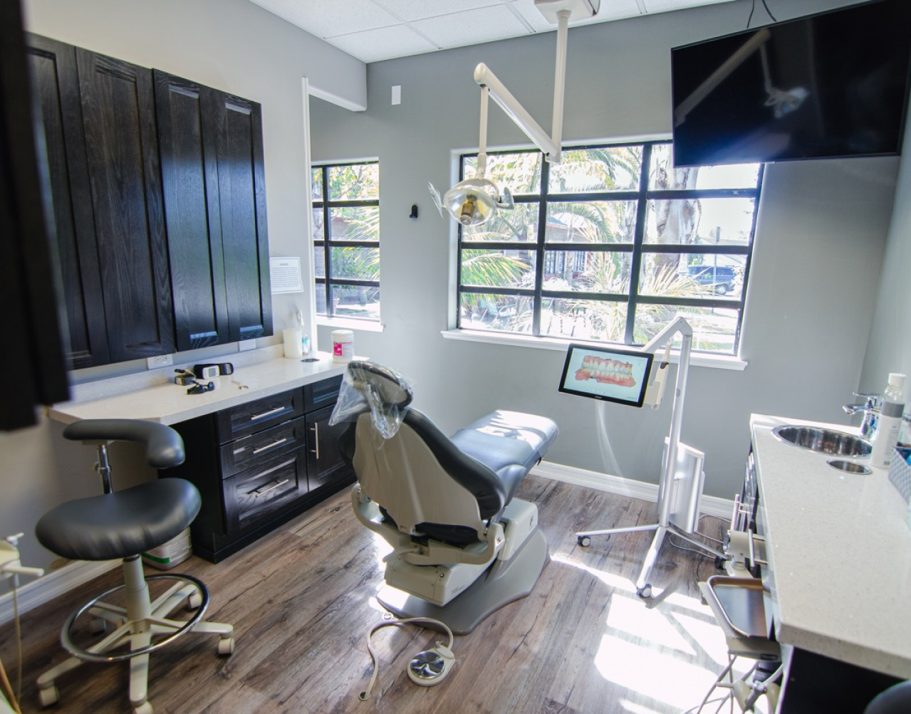 A dental office with a dental chair and a sink.
