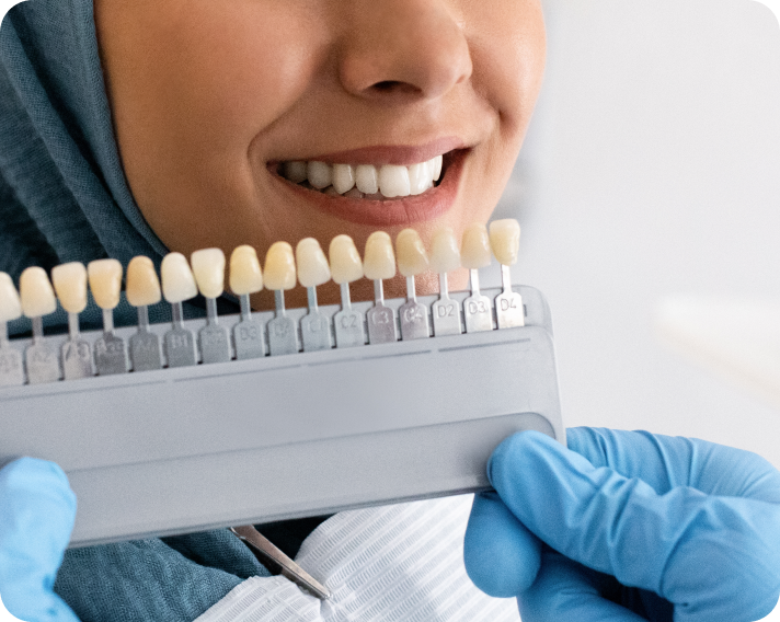 A woman is getting her teeth whitened by a dentist.