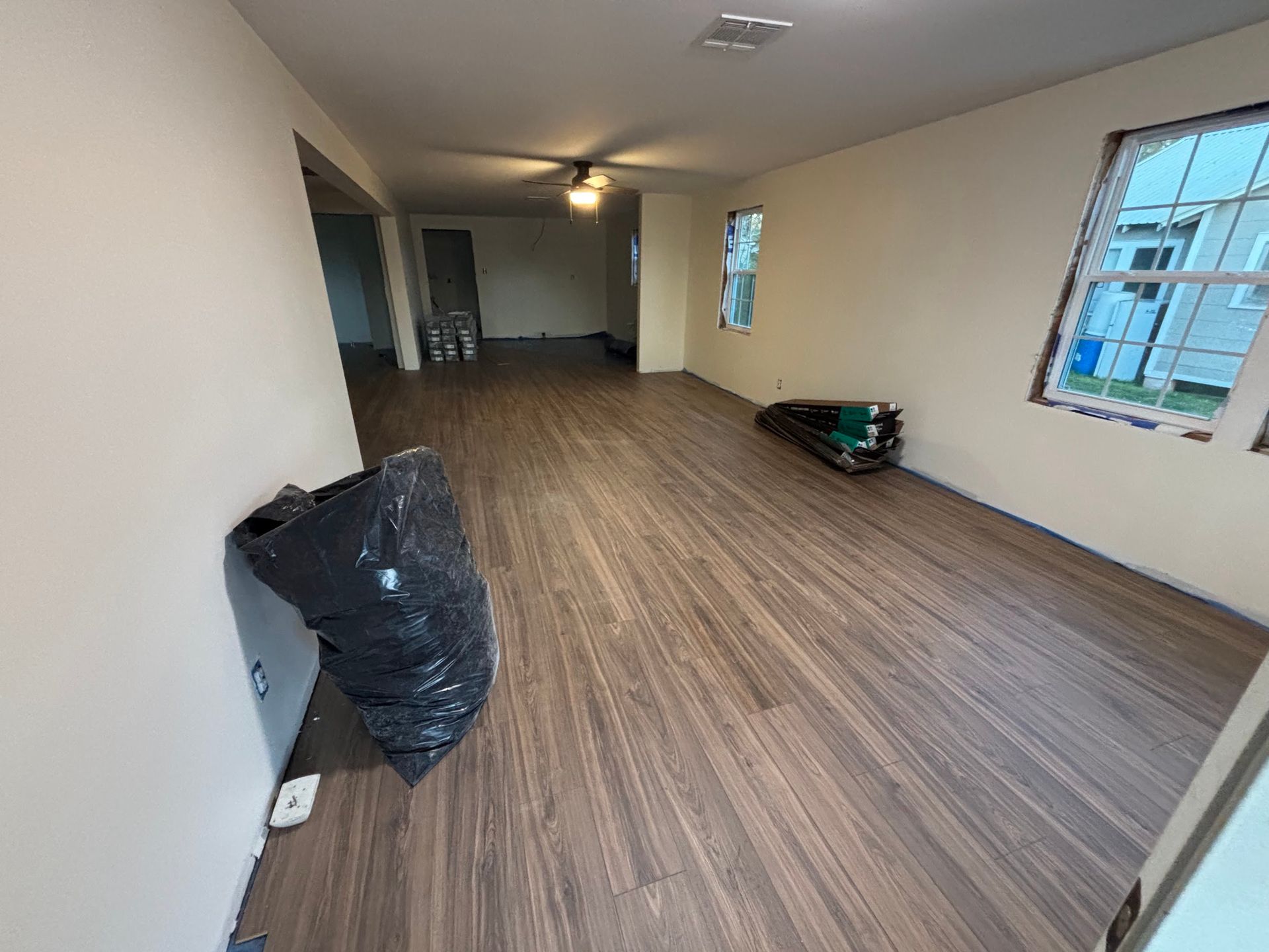 A living room with hardwood floors and a ceiling fan.
