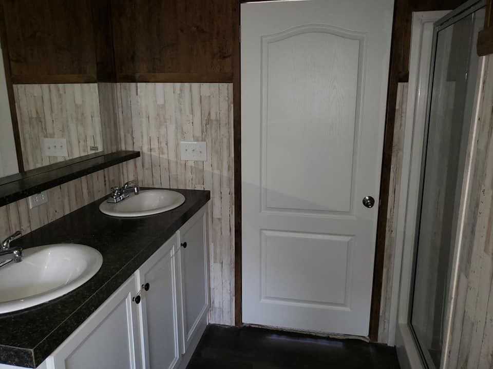 A bathroom with two sinks , a mirror and a door.