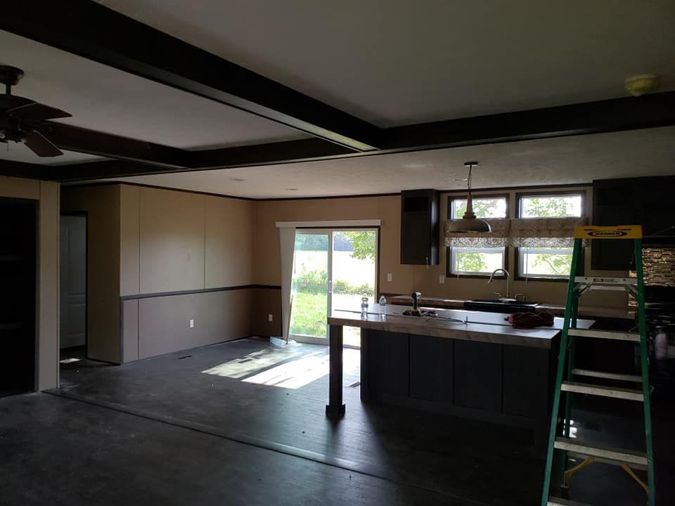 A kitchen with a ladder in the middle of it