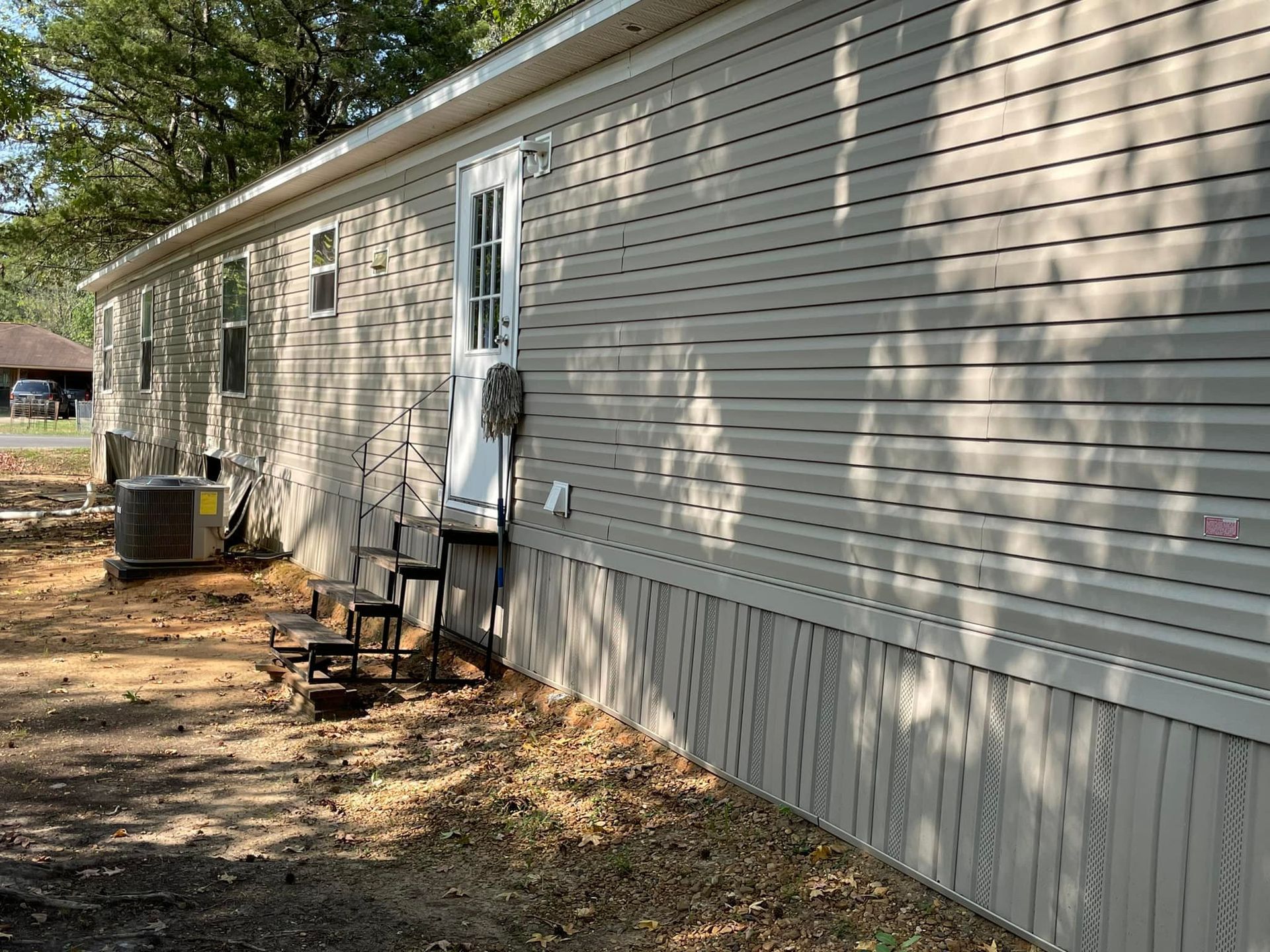 A mobile home with a ladder on the side of it.