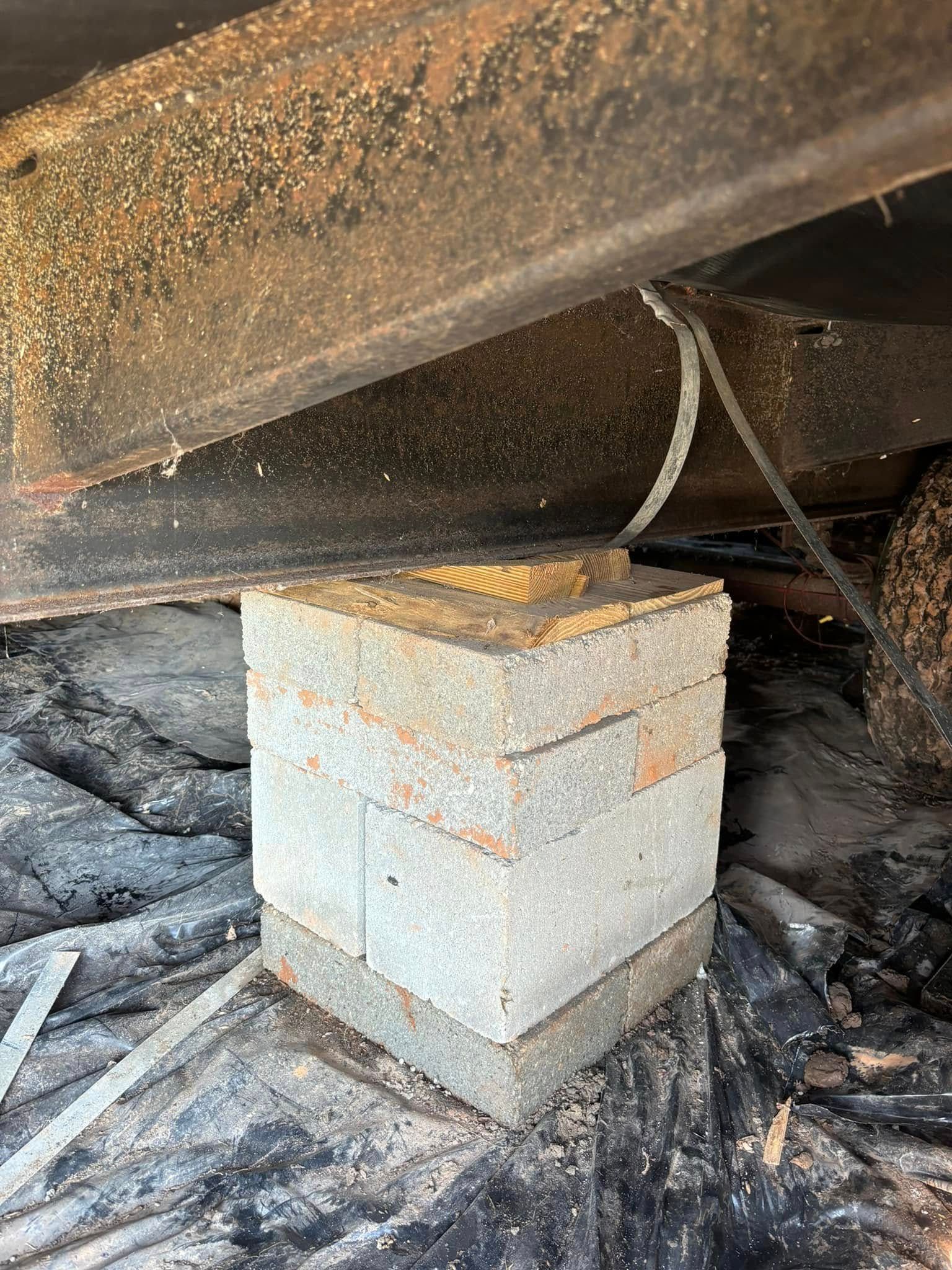 A brick block is sitting under a metal structure.