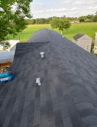 An aerial view of a roof with a shed in the background