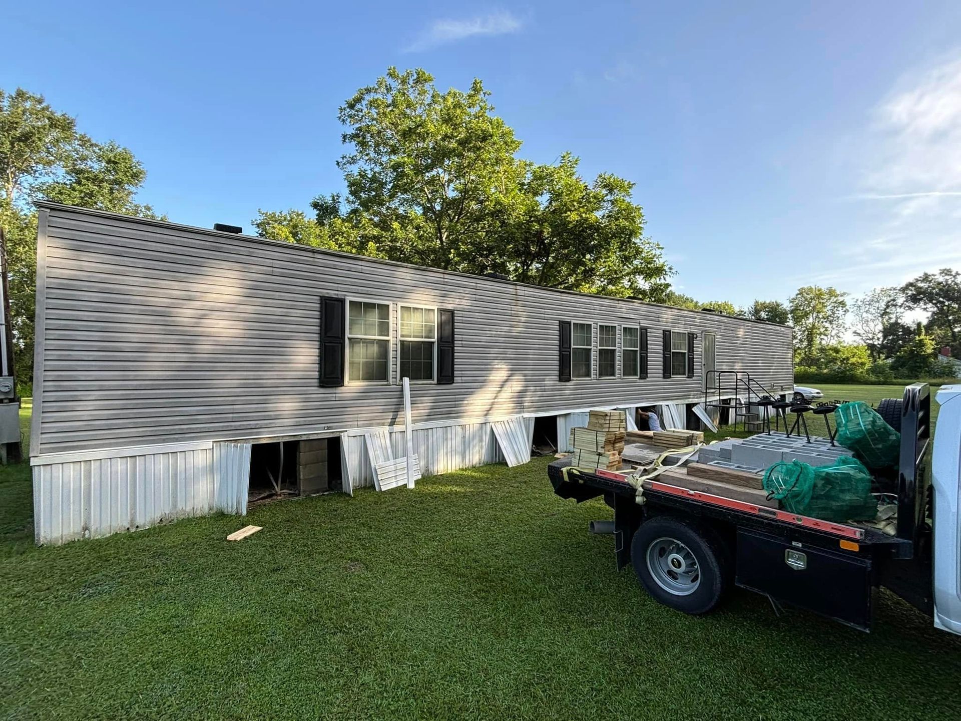 A tow truck is parked in front of a mobile home.