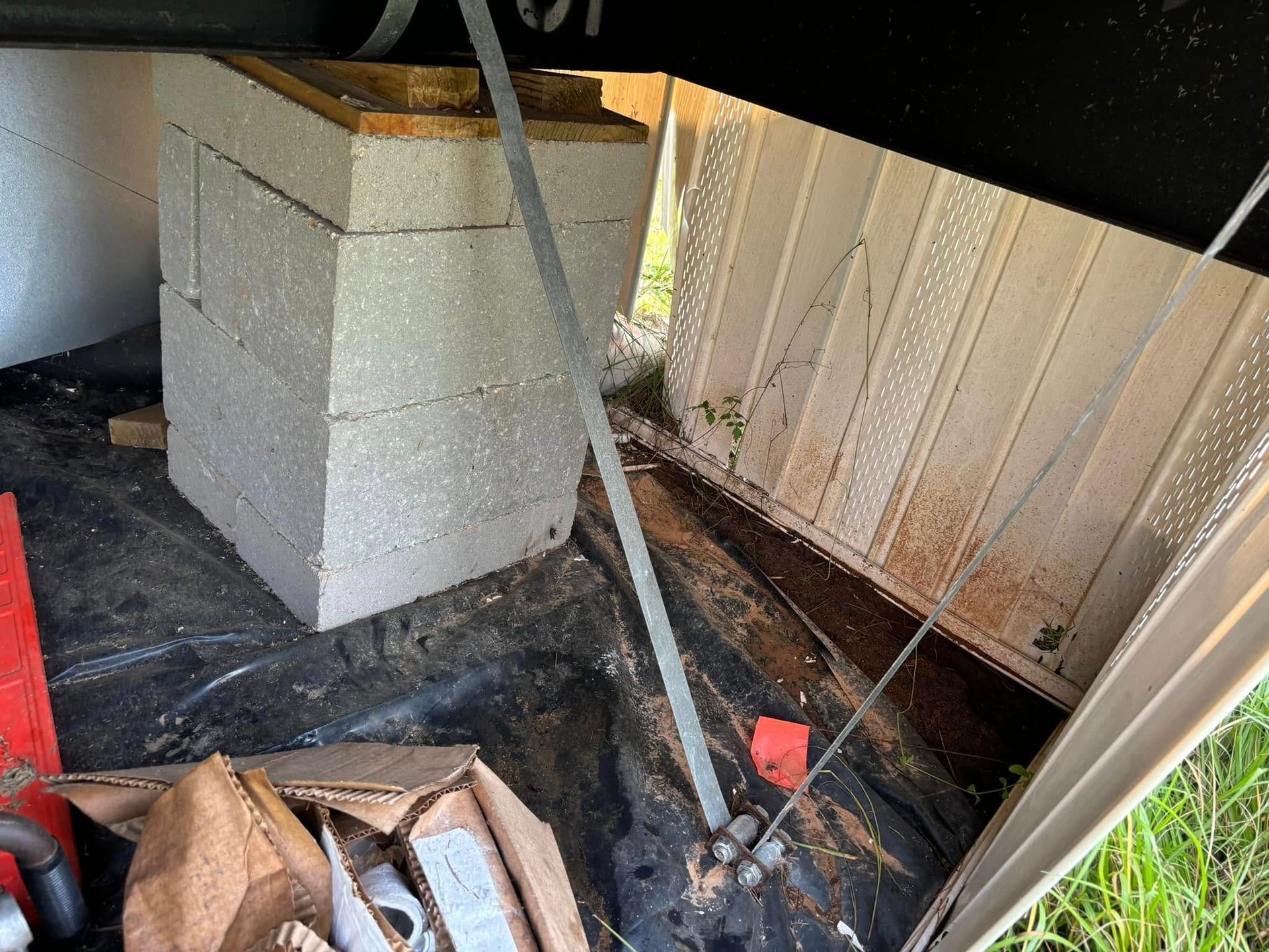 A concrete block is sitting on the ground under a building.