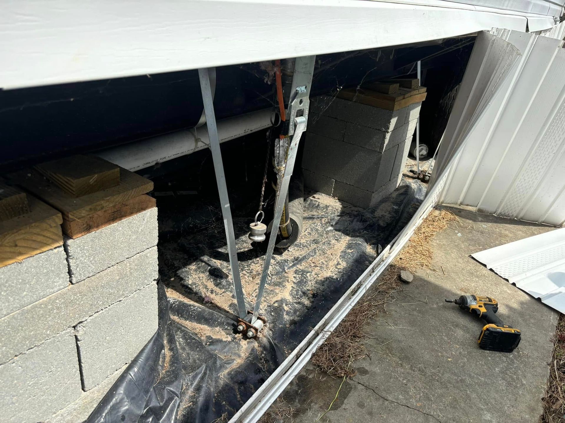 A person is working on a metal structure in a garage.