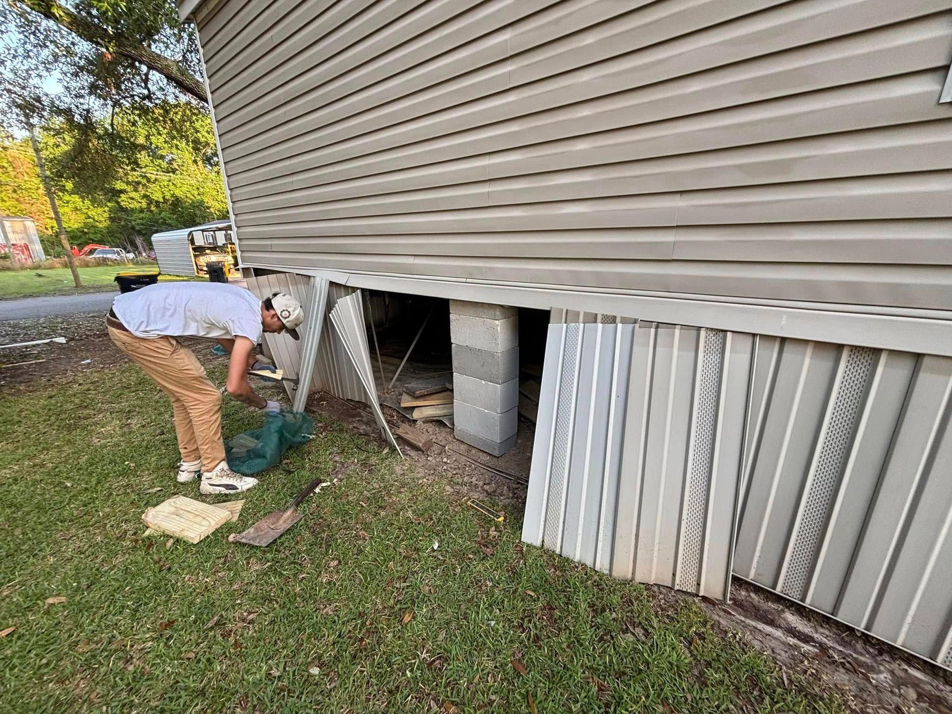 A man is digging in the basement of a house.