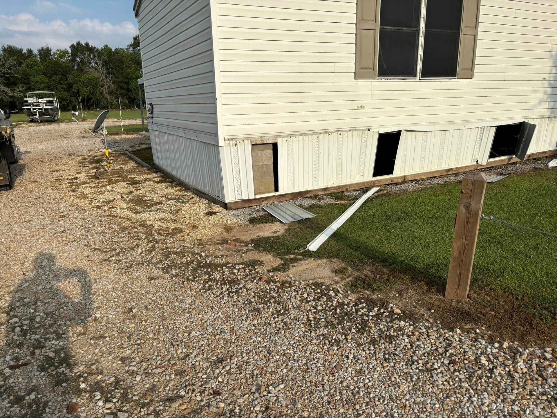 A mobile home is sitting on top of a gravel driveway.