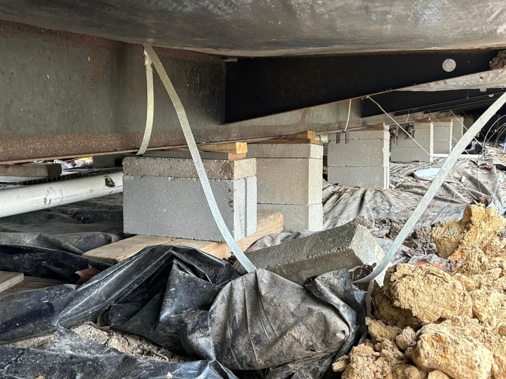 A pile of dirt is sitting underneath a metal structure.