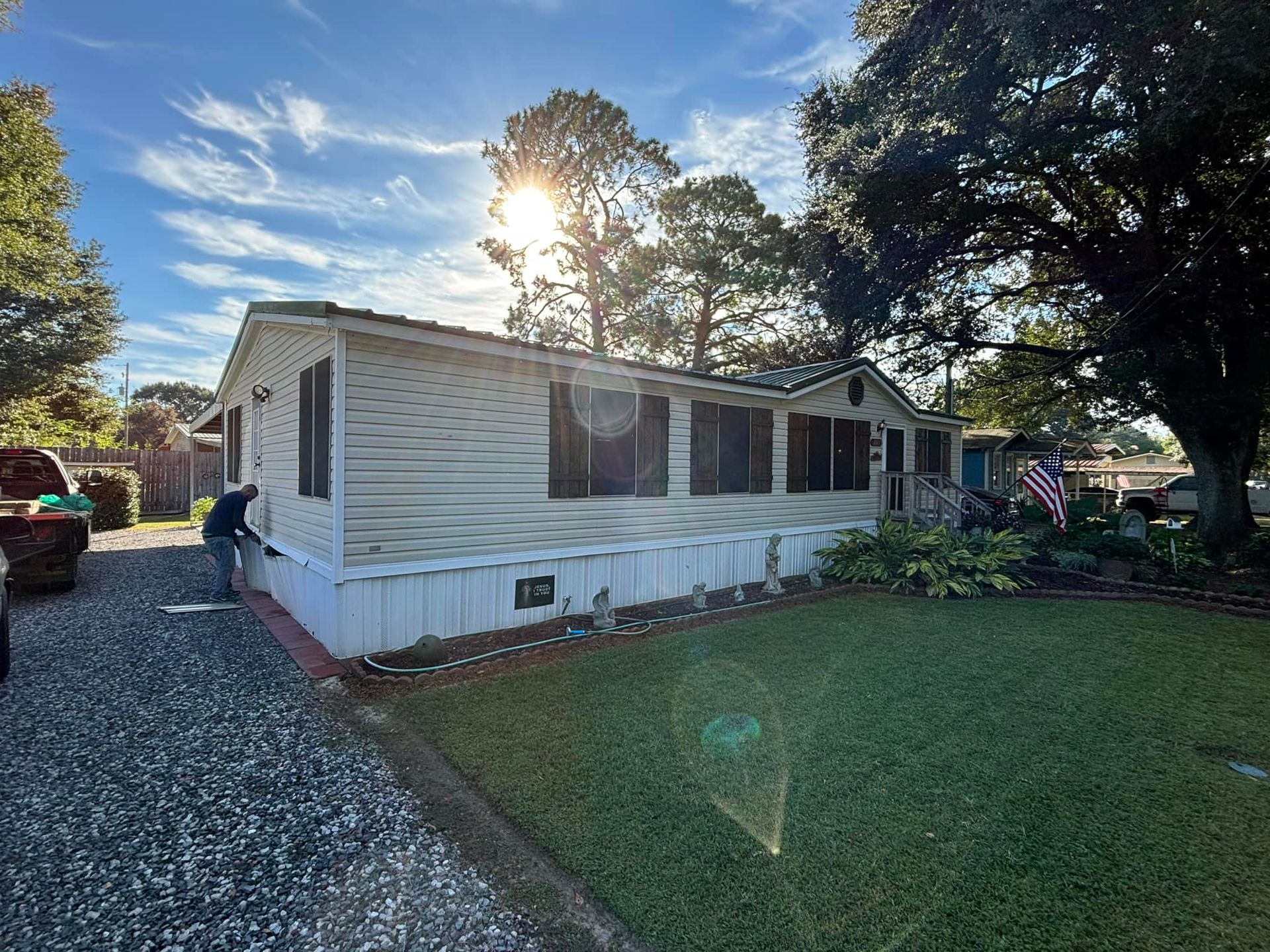 A man is painting the side of a mobile home.
