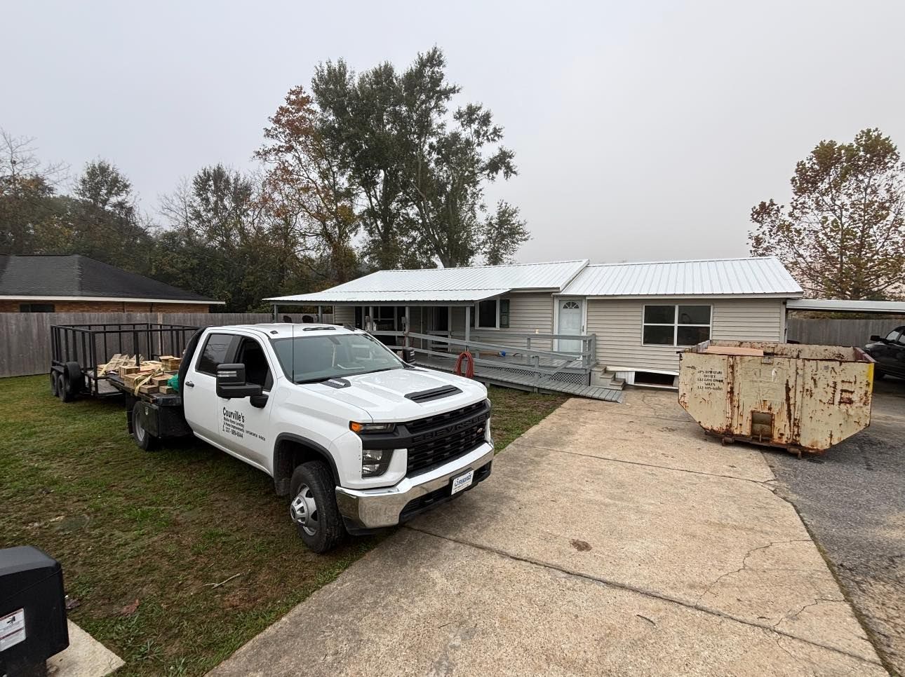 A white truck is parked in front of a house.