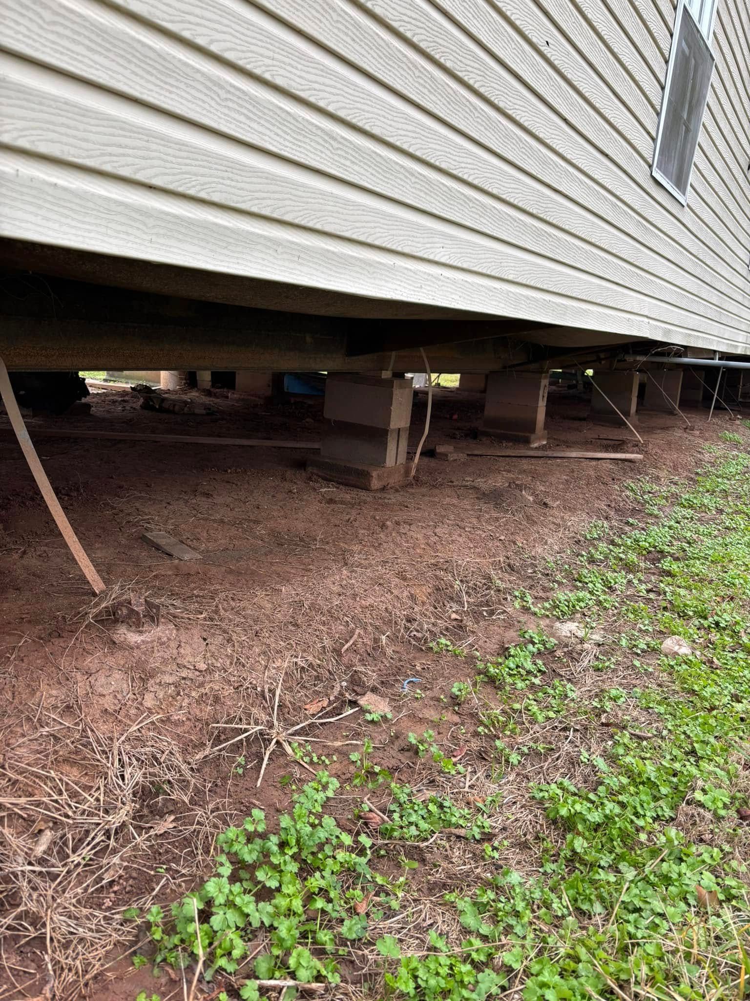 A mobile home is sitting on top of a dirt field.