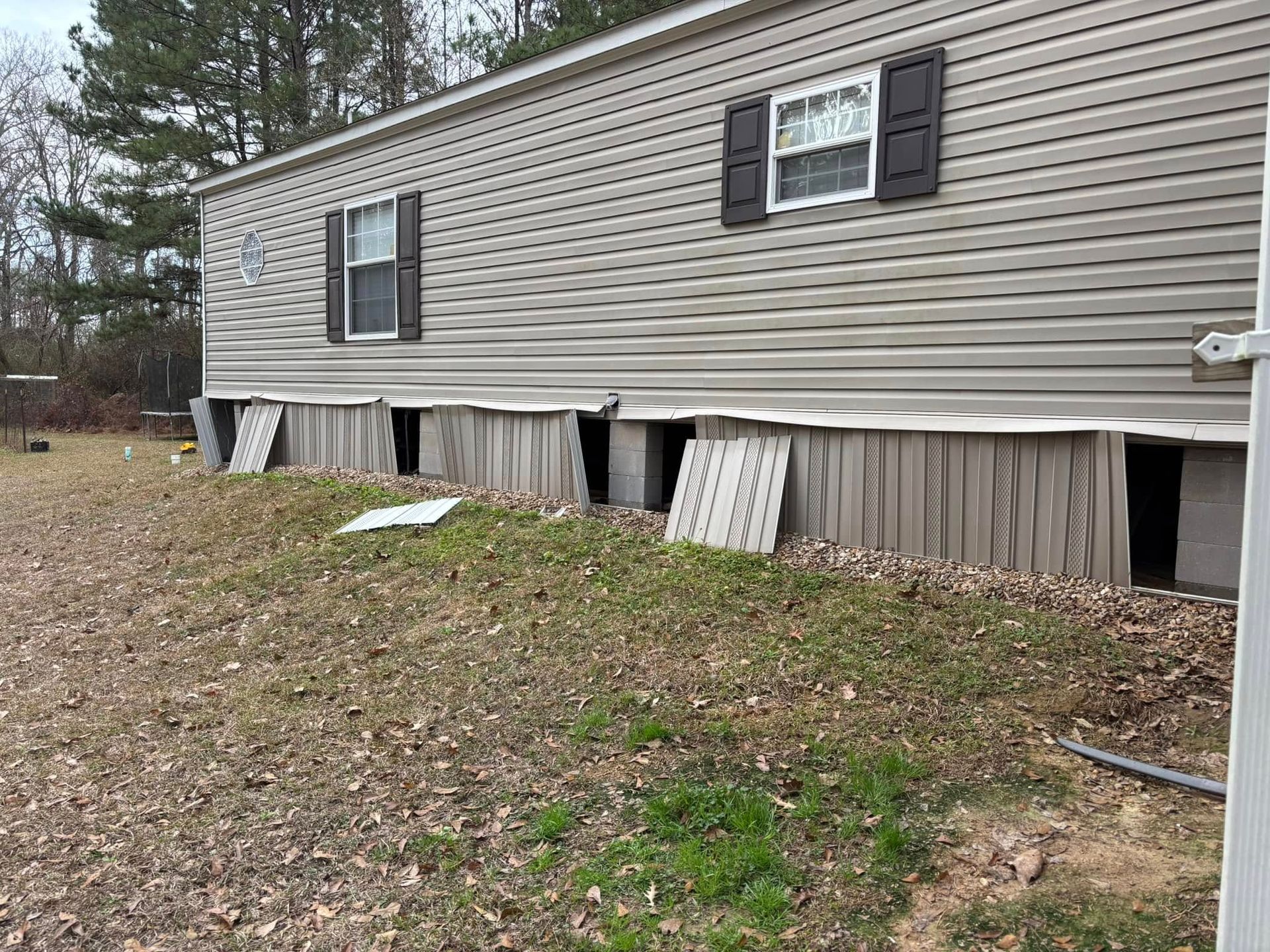 A mobile home is sitting on top of a dirt field.