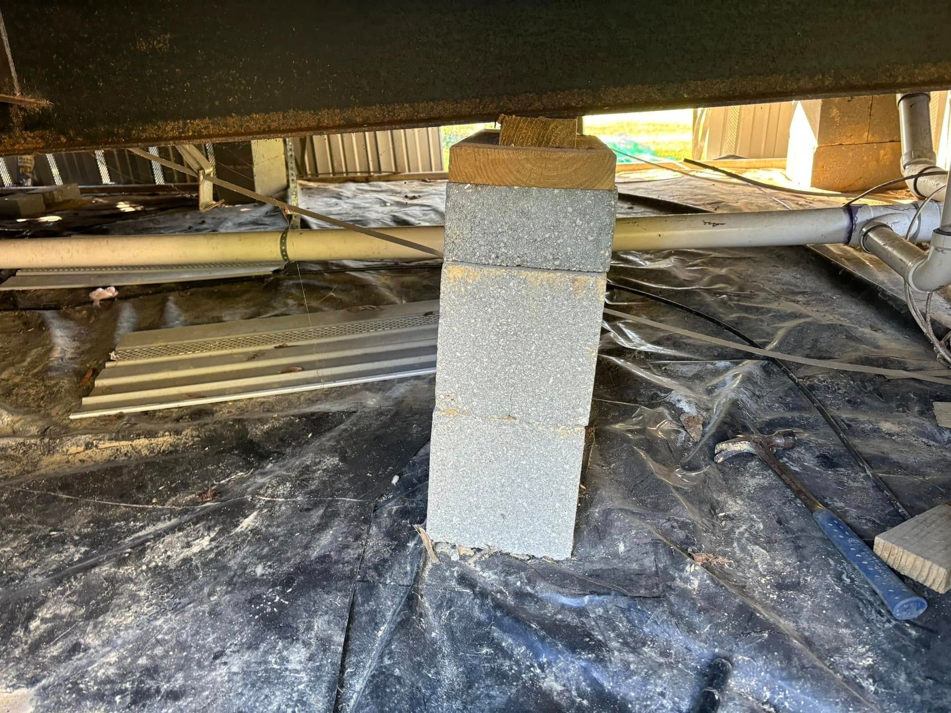 A concrete post is sitting on top of a plastic tarp.