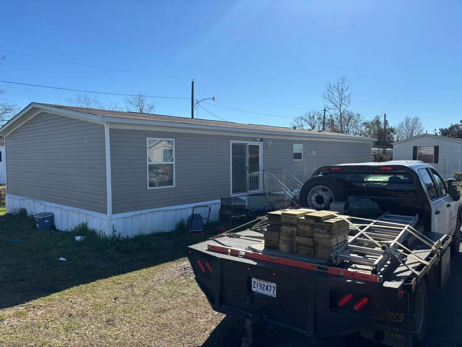 A truck is parked in front of a mobile home.
