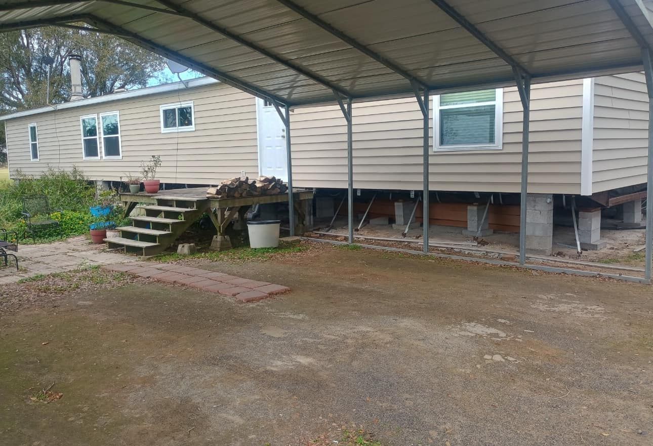 A mobile home with a carport in front of it.