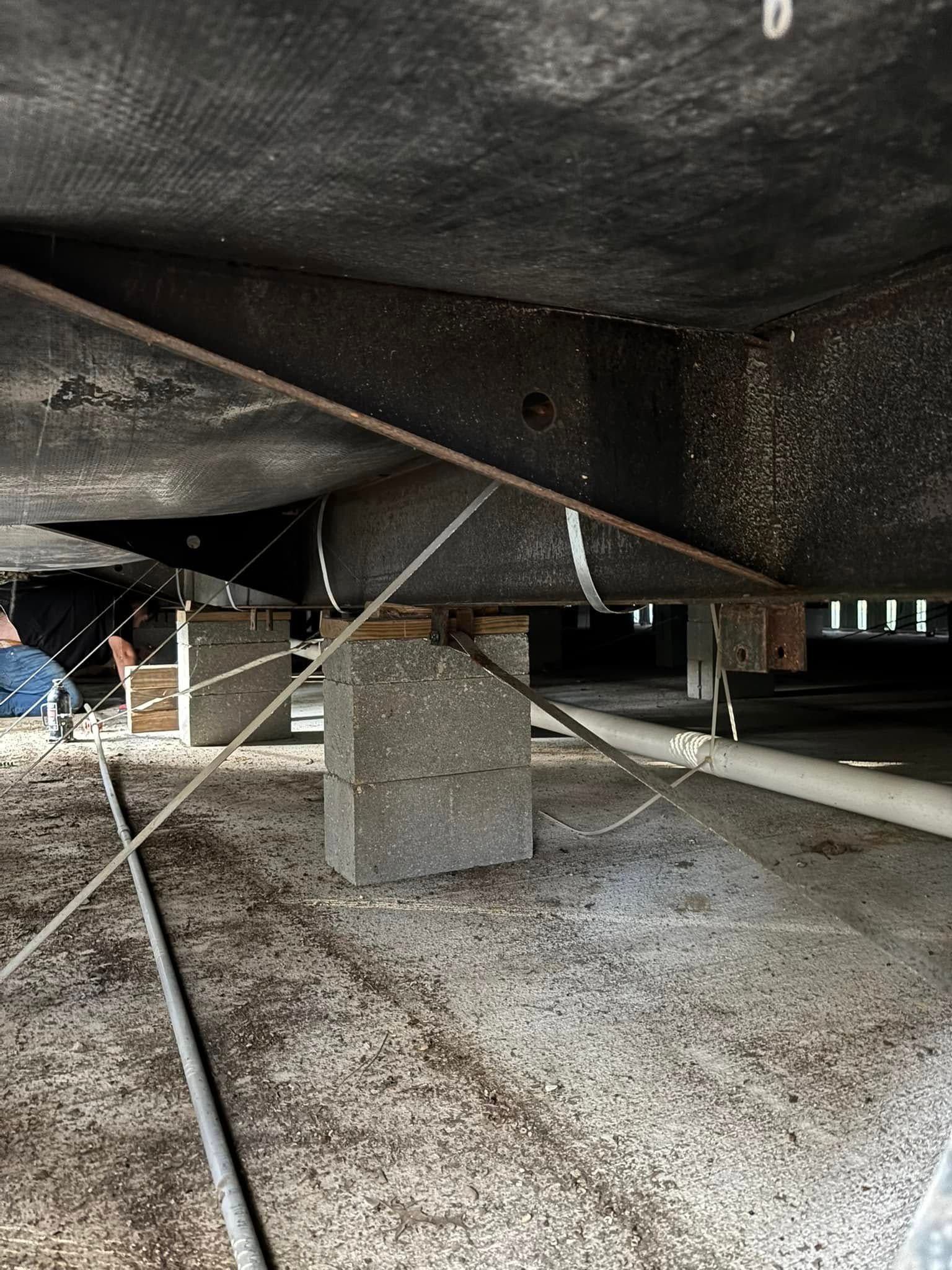 A concrete block is sitting underneath a metal structure.