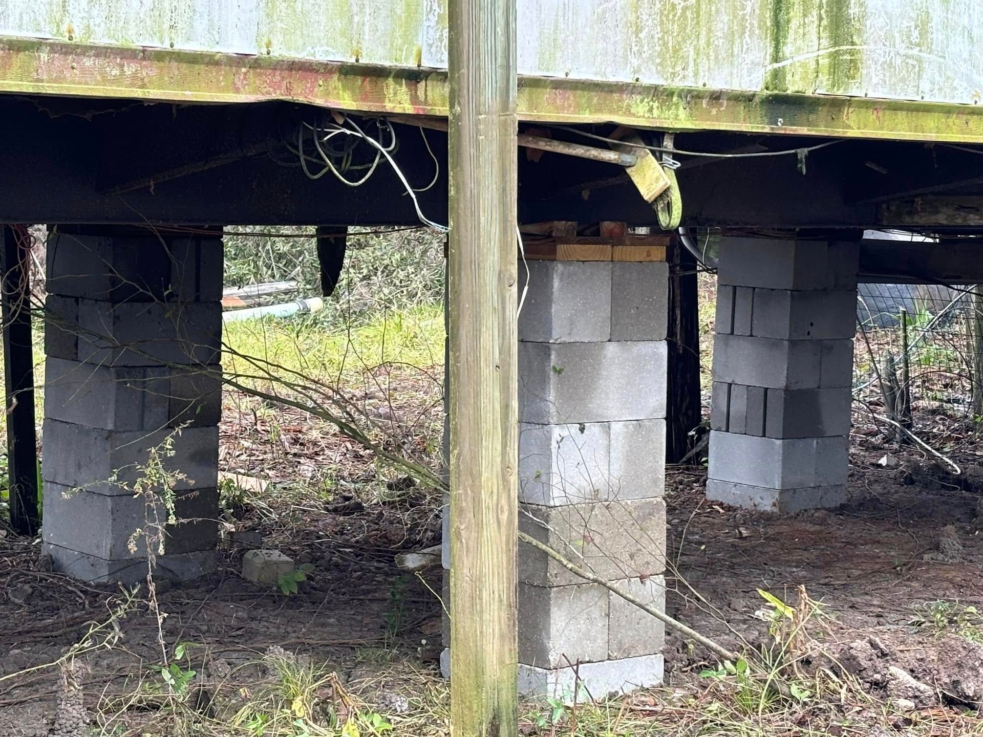 The foundation of a house is supported by concrete blocks.