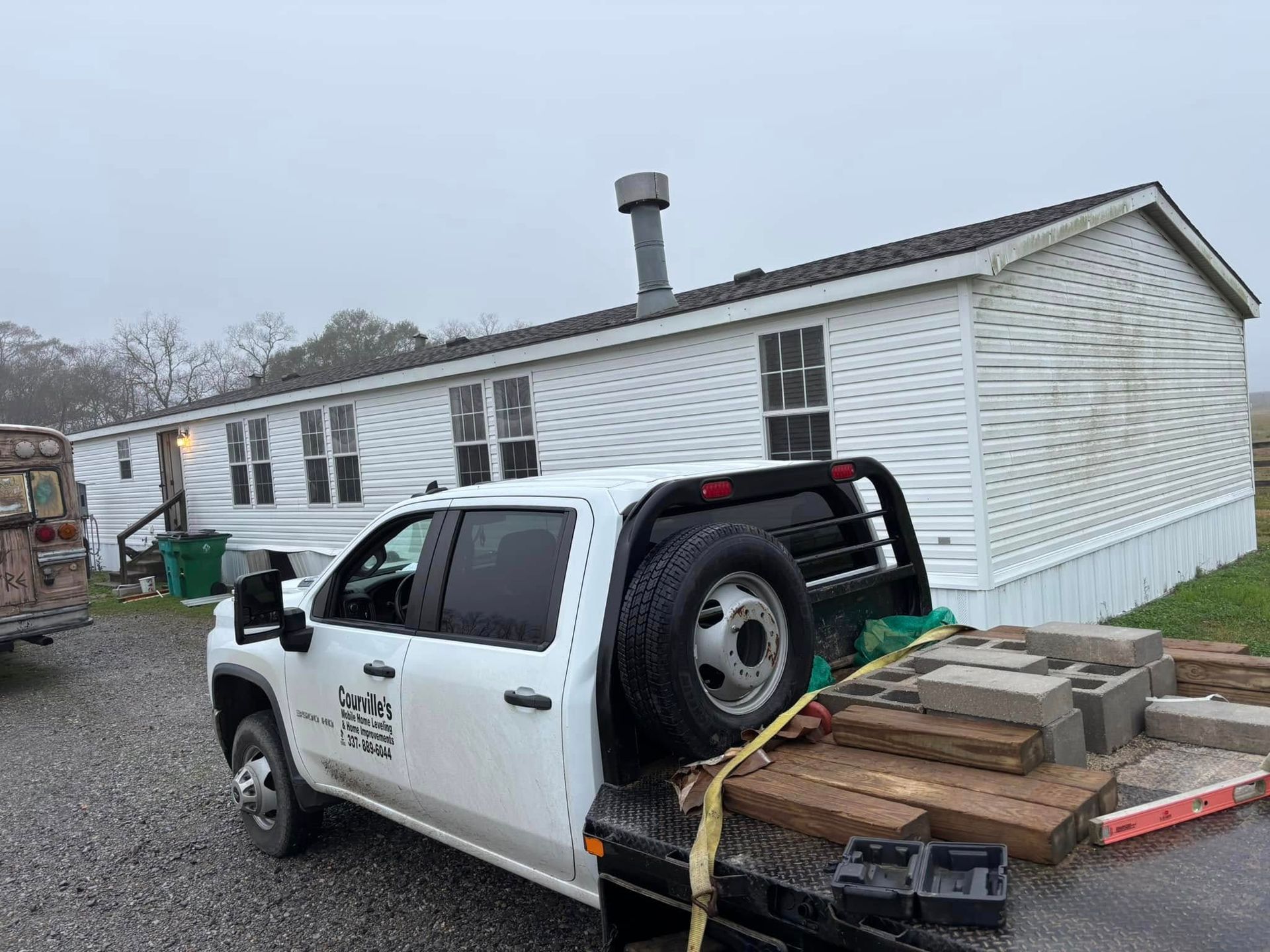 A white truck is parked in front of a mobile home.