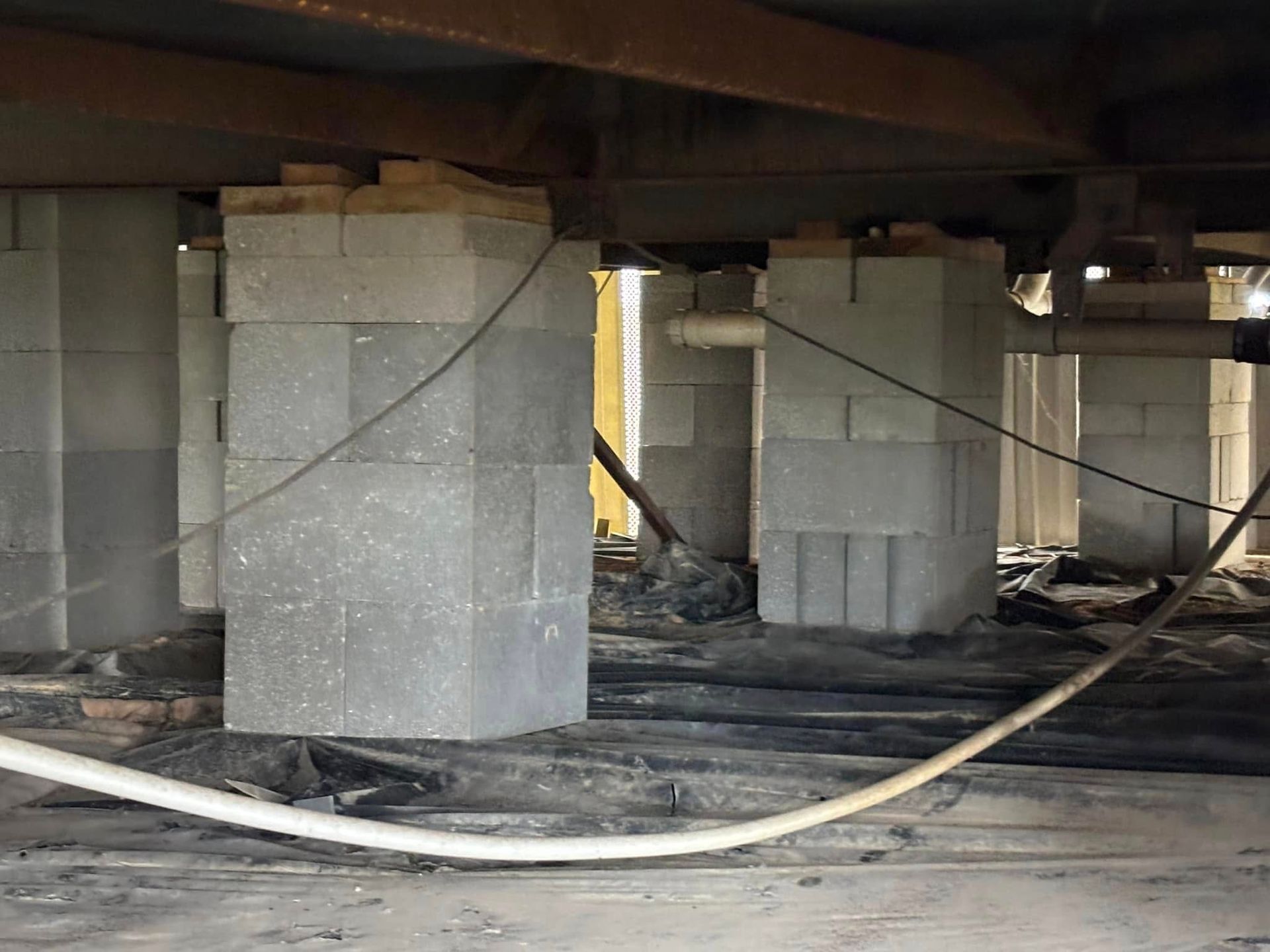 A room with a lot of concrete pillars and wires