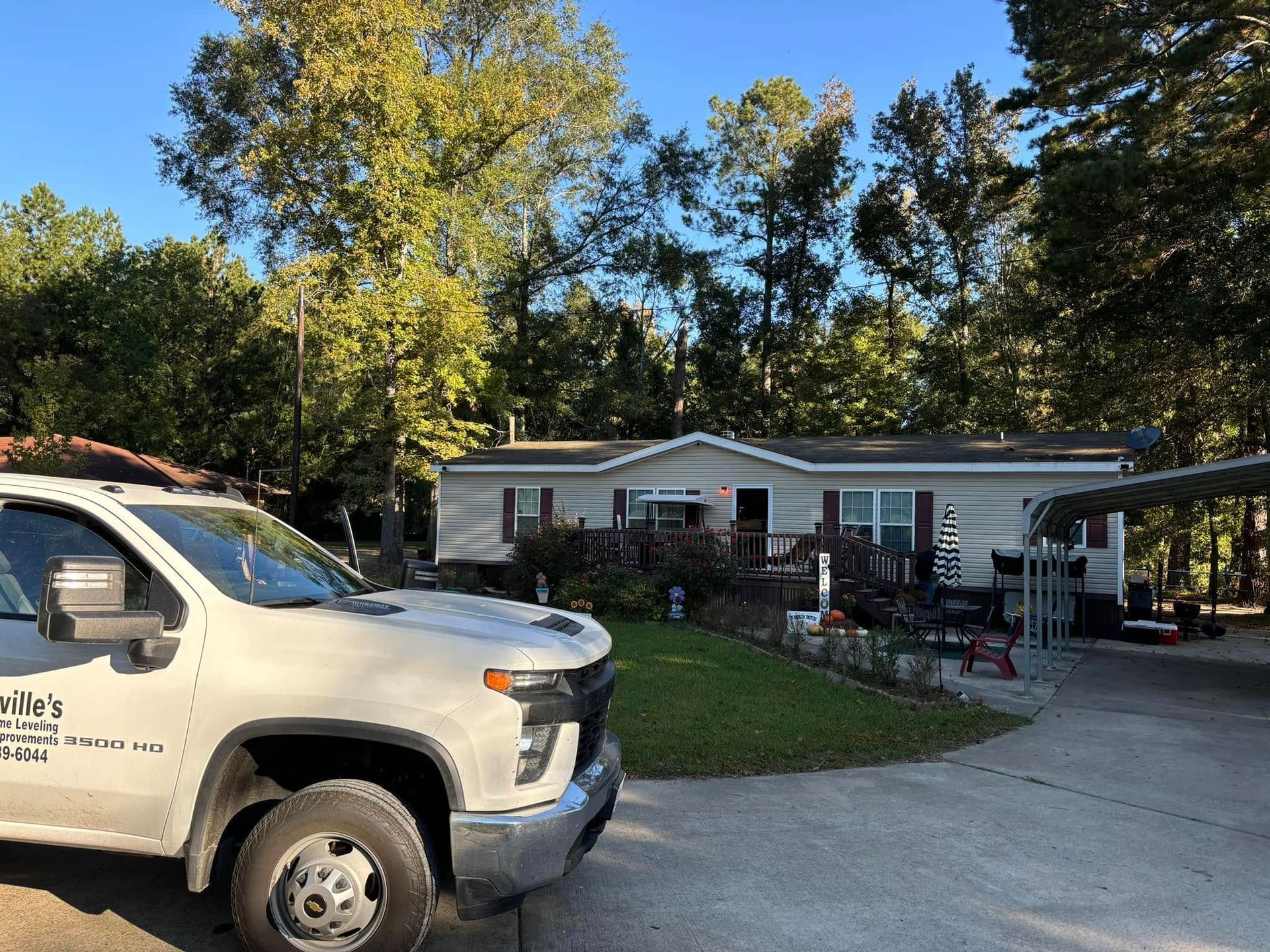 A white truck is parked in front of a mobile home.