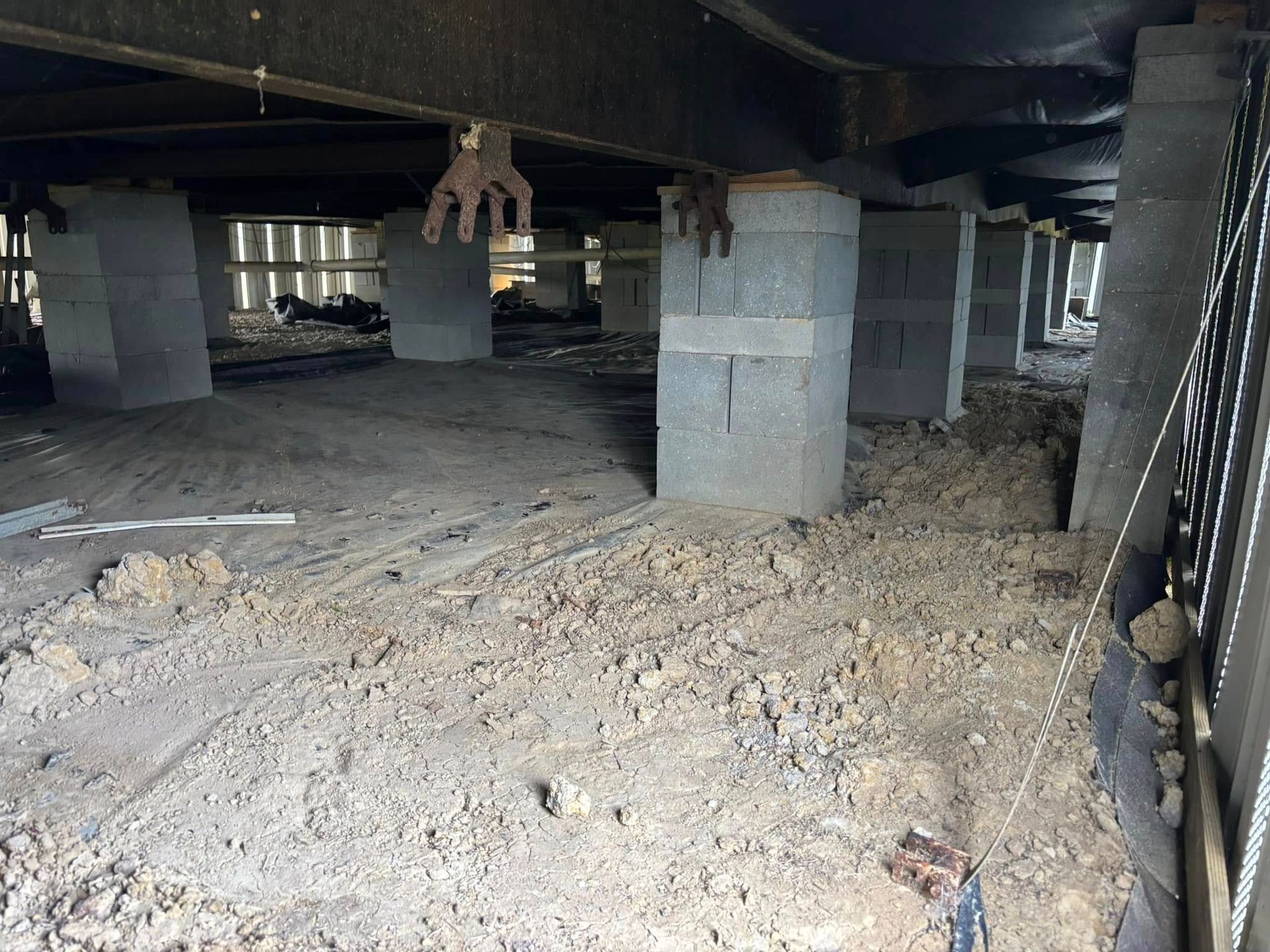 A pile of dirt is sitting under a bridge.