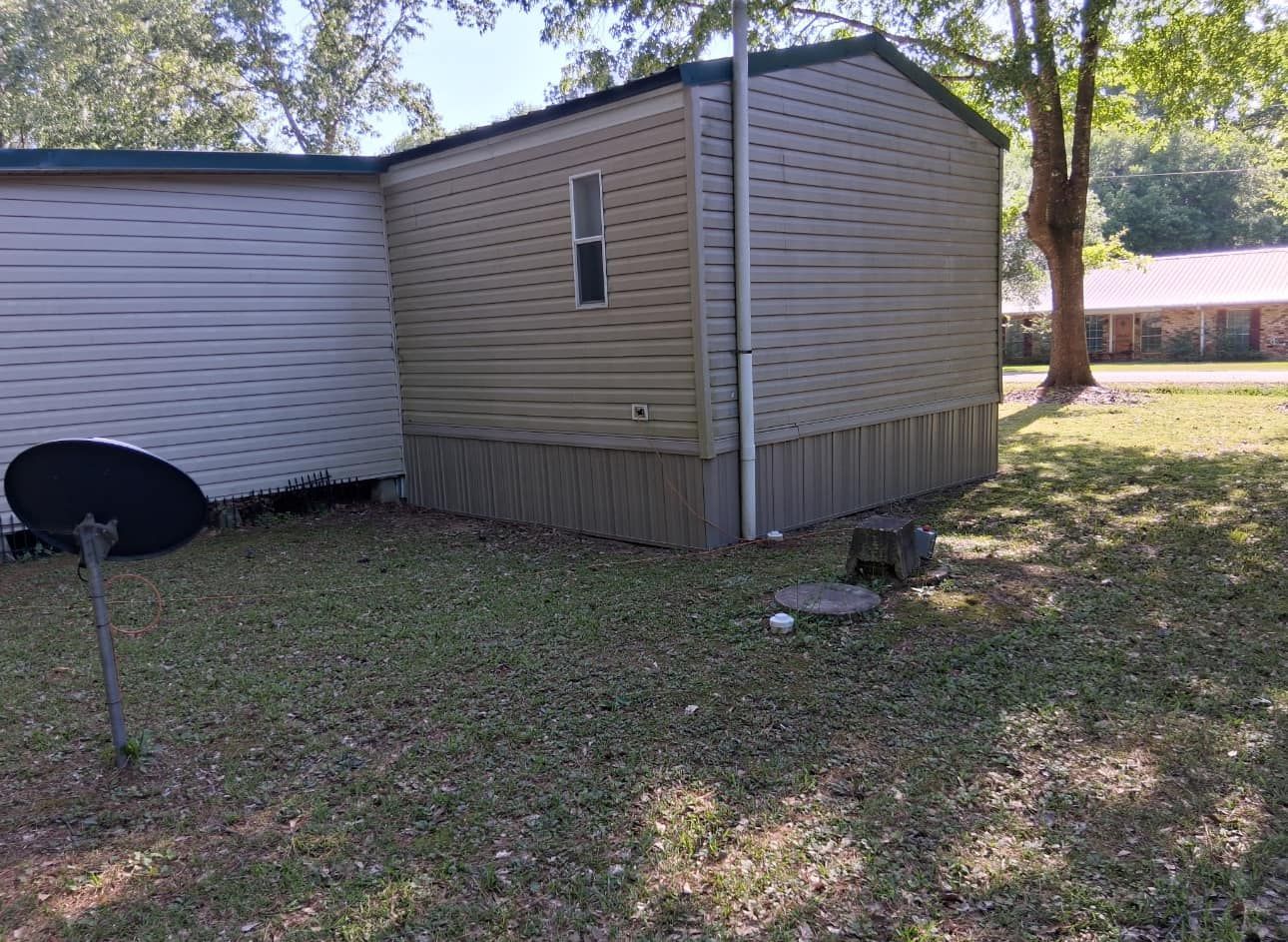 A mobile home is sitting on top of a lush green field.