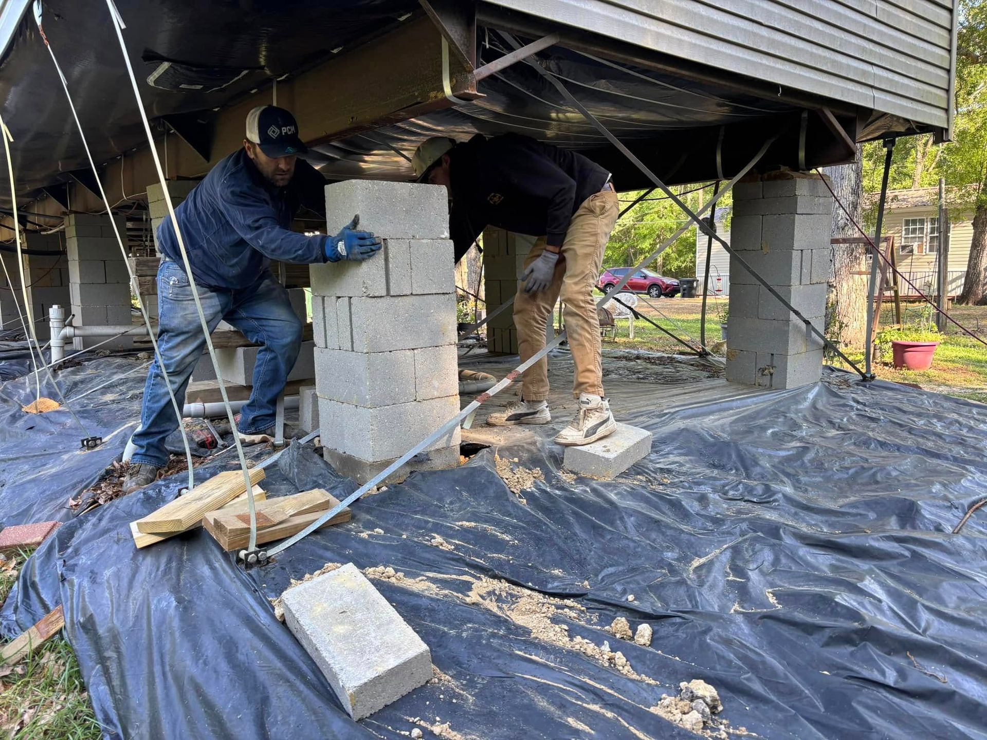 A group of men are working on the foundation of a house.