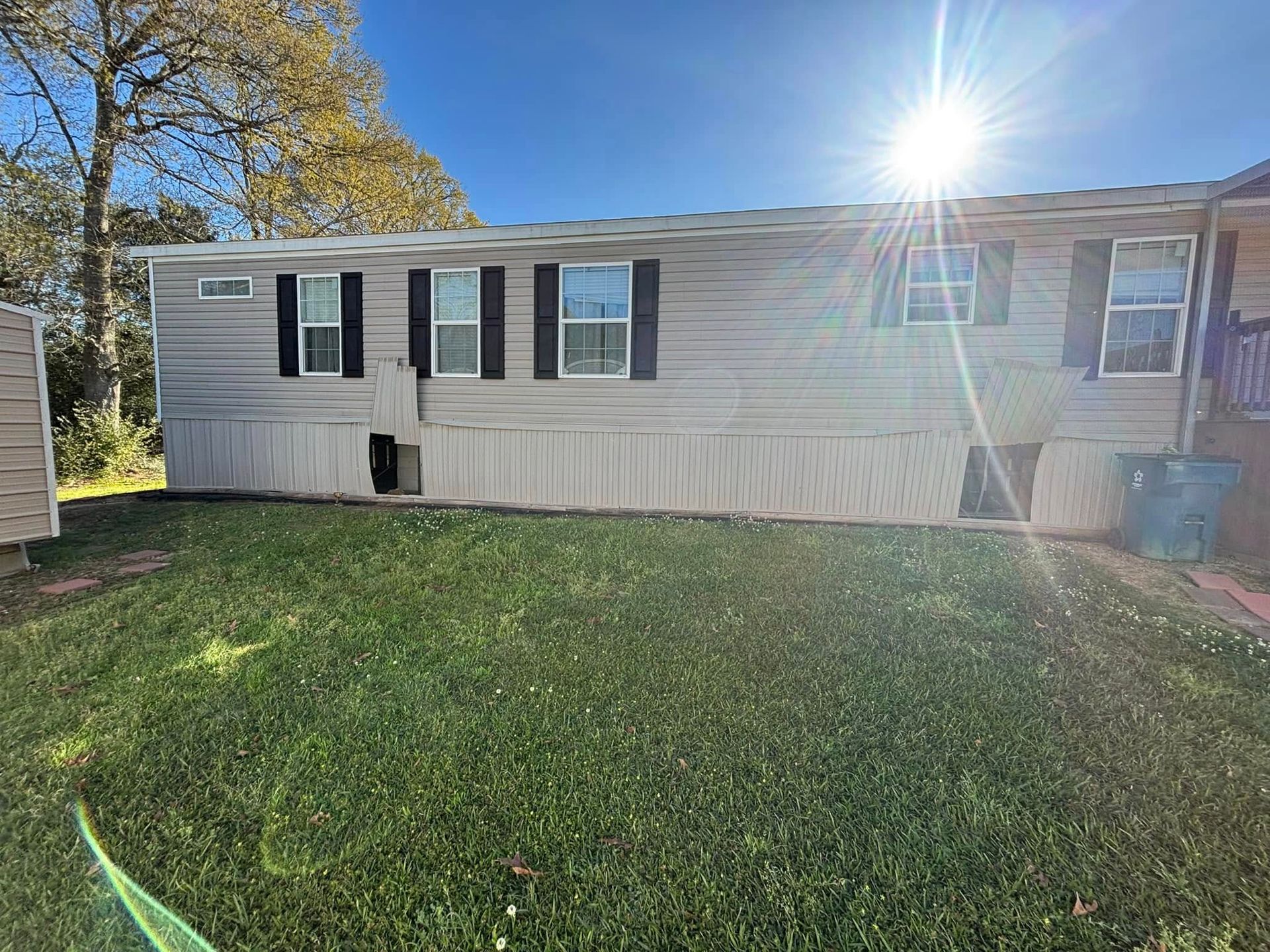 A mobile home is sitting on top of a lush green lawn.